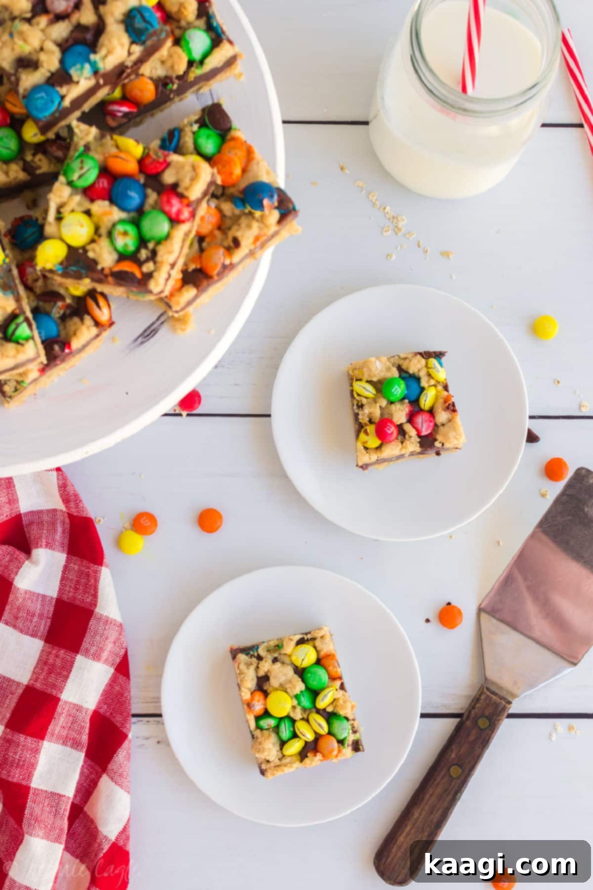 M and M Chocolate Chip Oat Bars 7 two plates with an M&M chocolate oat bar on each, with a cake stand filled with them.