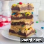 M and M Chocolate Chip Oat Bars 8 Close up of a stack of M&M Chocolate oat bars with a glass of milk in the background.