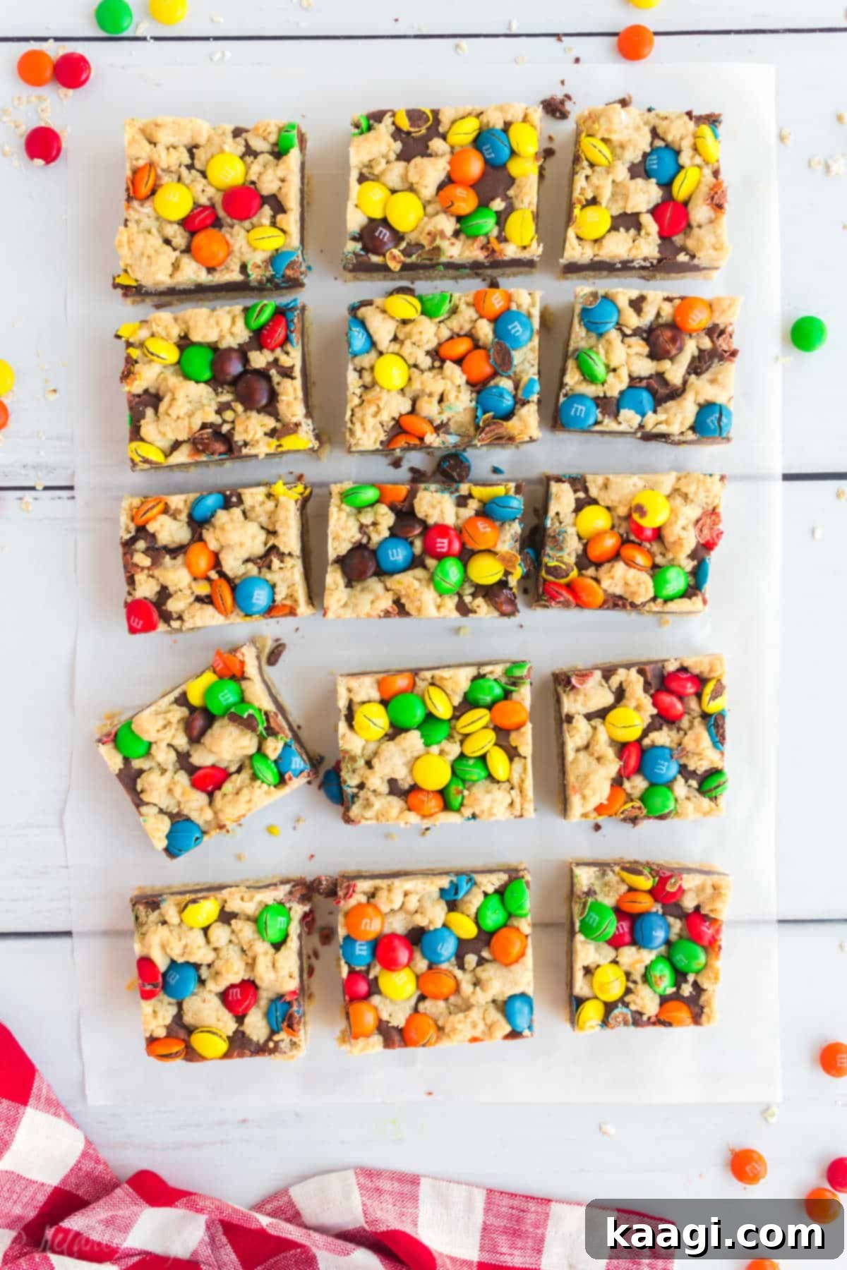 M and M Chocolate Chip Oat Bars 5 M&M Chocolate Oat Bars cut into squares on a parchment paper.