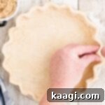 Hands fluting the edges of an Amish Pie Crust.