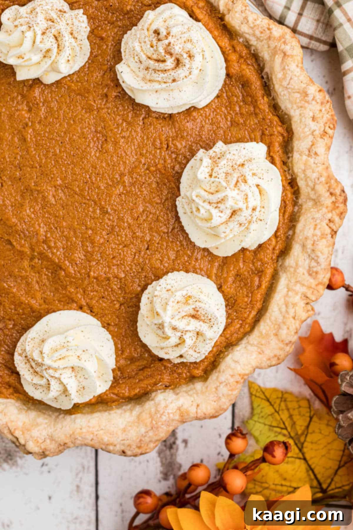 Close up shot of an old fashioned sweet potato pie with swirls of cream, showcasing the pie crust.