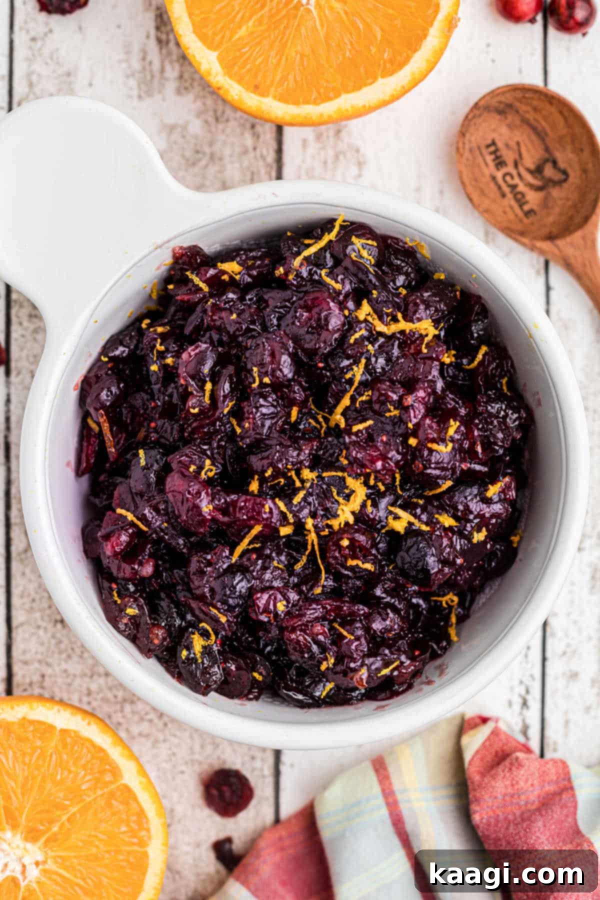 Close up overhead shot of a bowl of dried cranberry sauce with some orange zest on top.