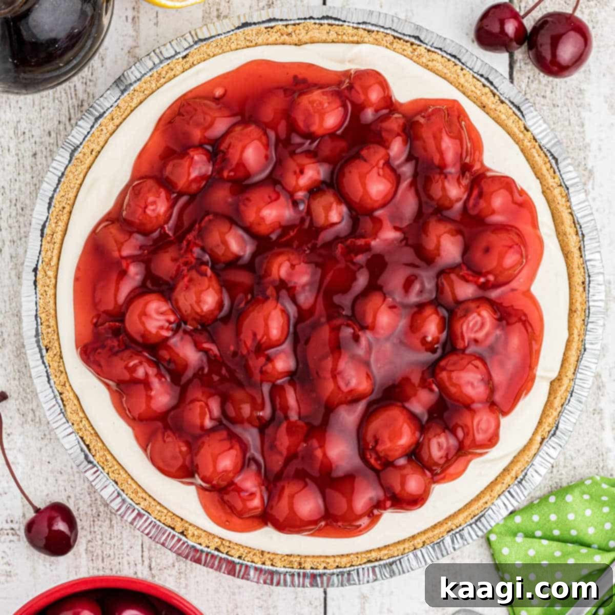 Close up overhead shot of a no bake cherry pie with a golden graham cracker crust, showcasing its vibrant cherry topping.