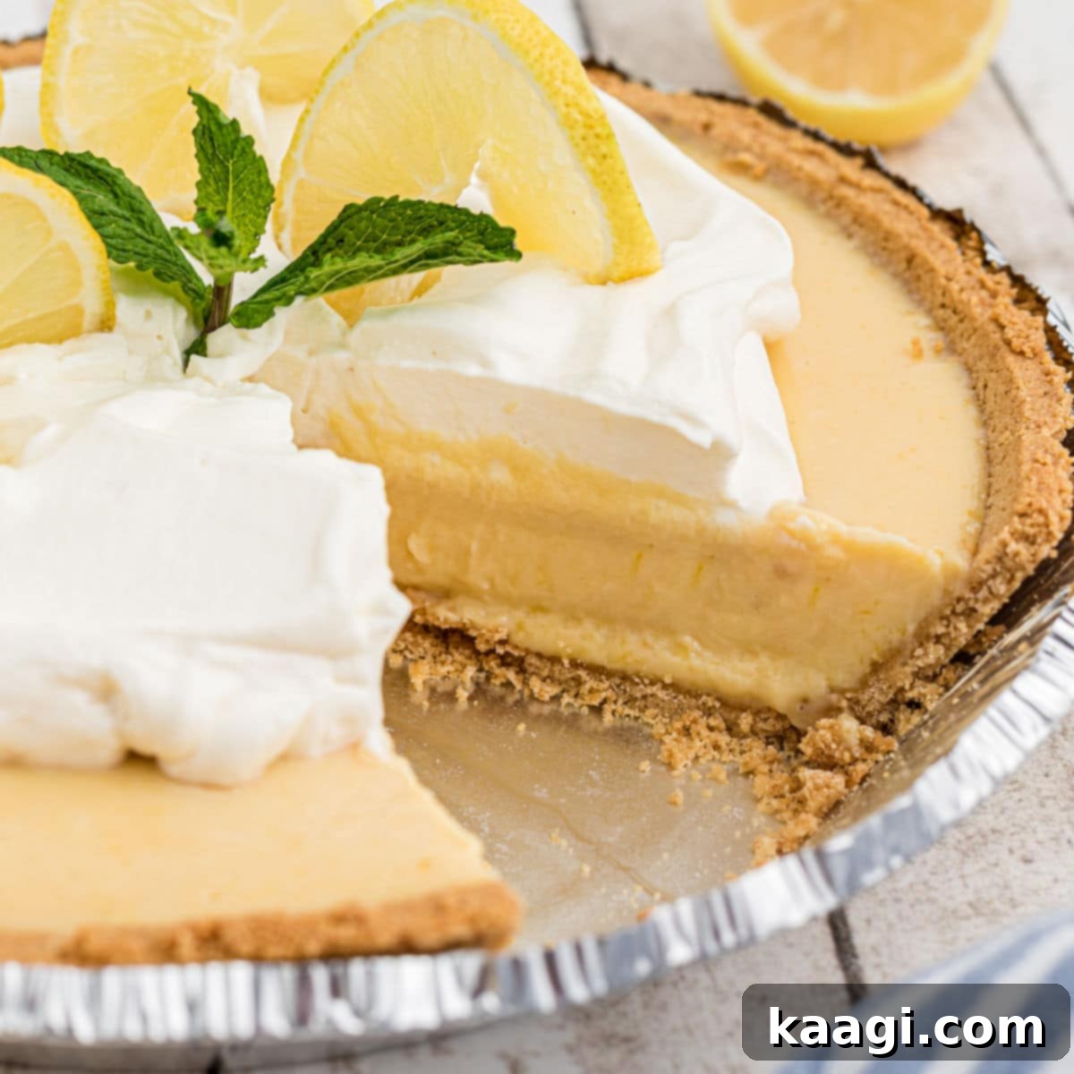 Square cropped shot of the inside of a southern lemon pie with some cream and lemon slices on top, highlighting its bright, zesty appeal.