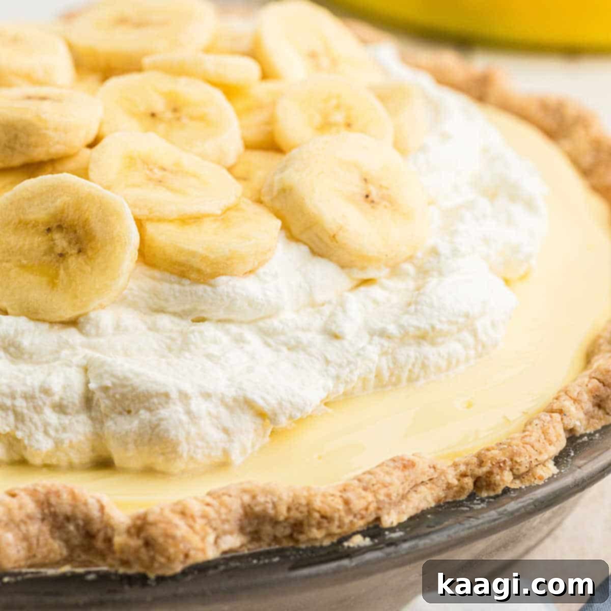 A dish with banana cream pie, cropped square, displaying its creamy layers and banana slices.