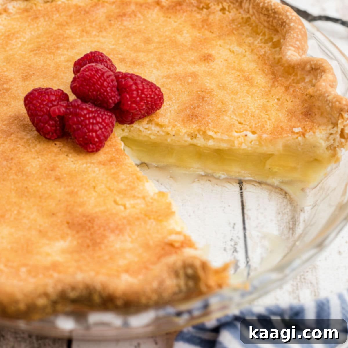 Close up shot of a cracker barrel buttermilk pie with a slice taken out of it, showing its unique custard filling.