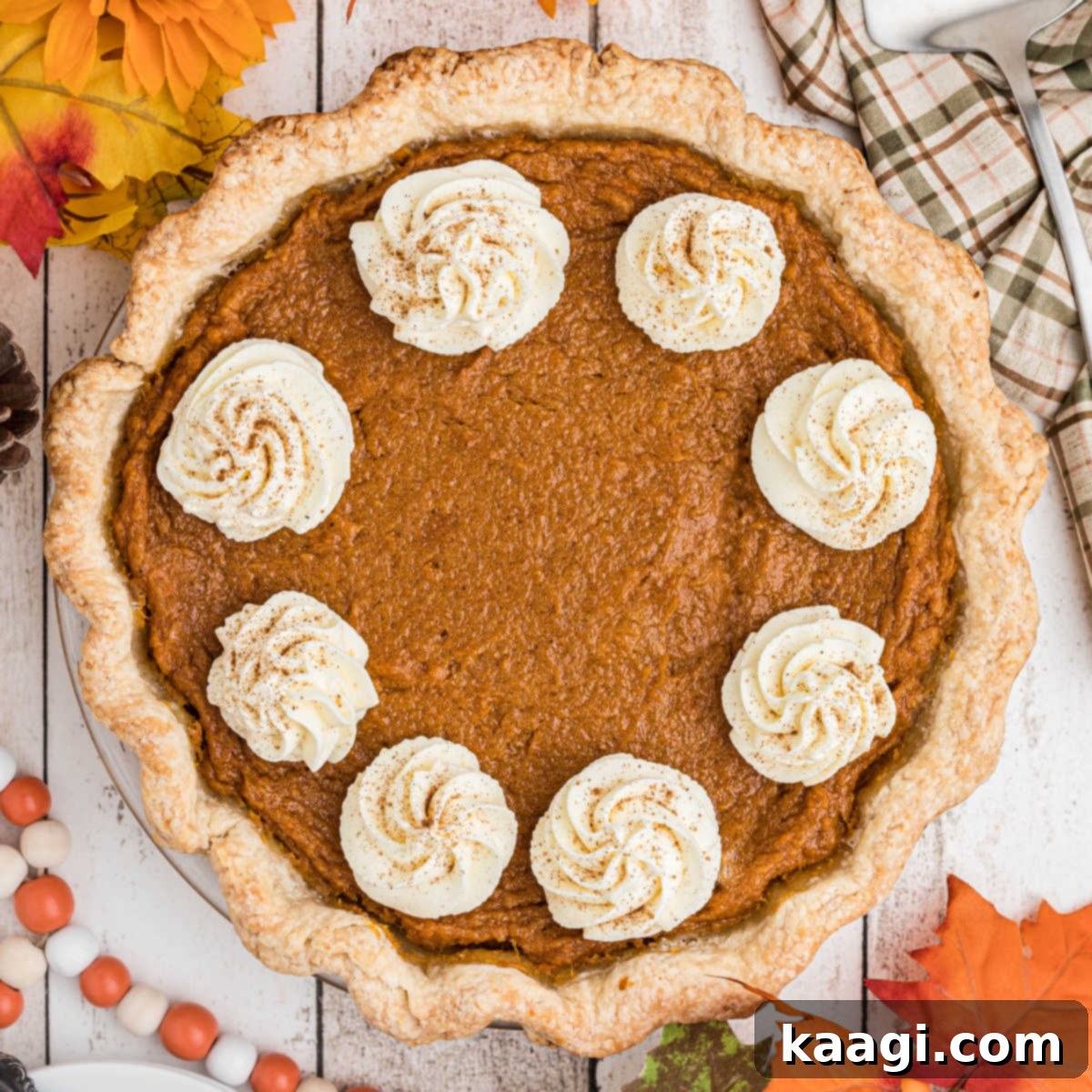 Overhead shot of a sweet potato pie with swirls of cream, ready to be served.
