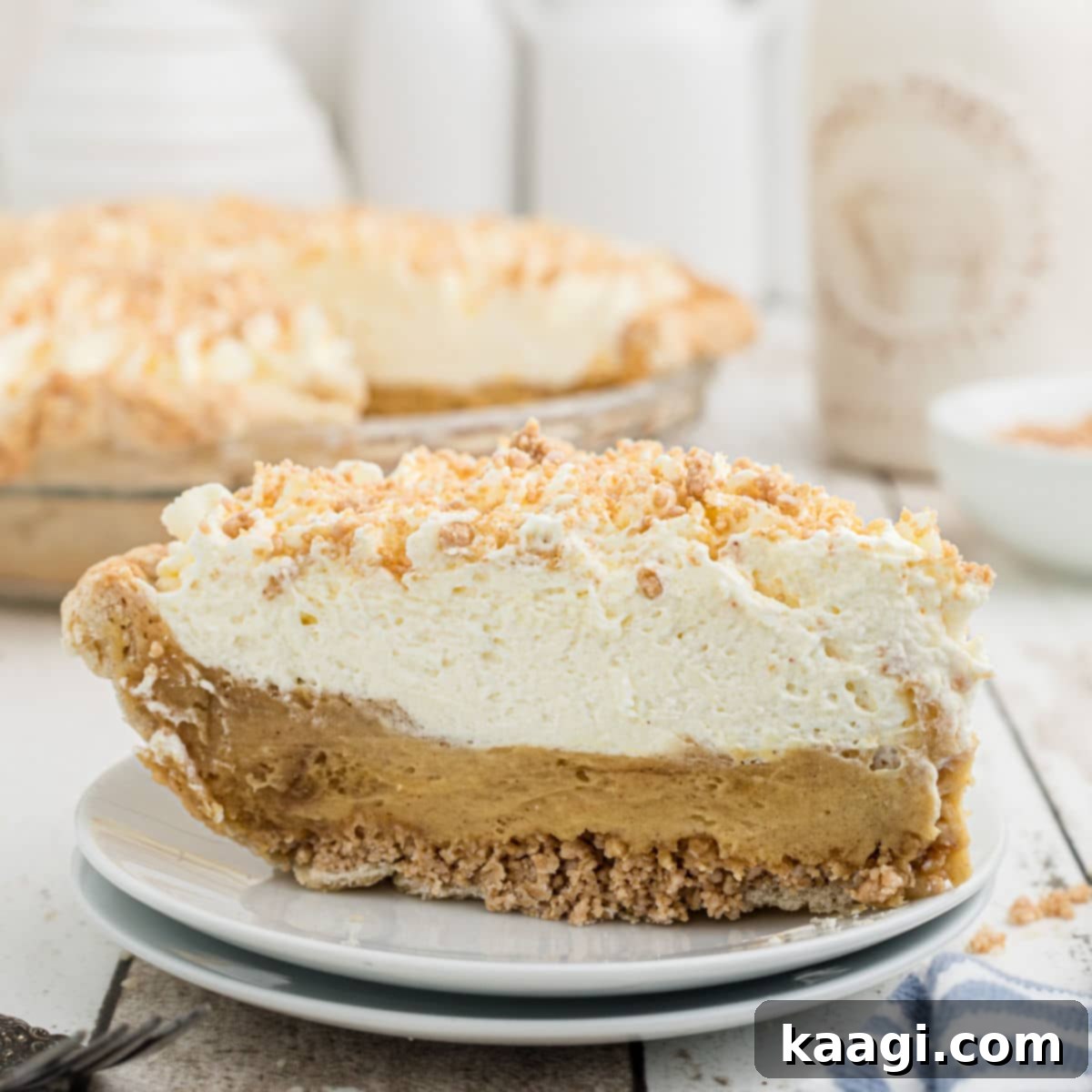 A slice of Amish Peanut Butter Pie on a plate with the pie dish behind, showing its distinct layers.