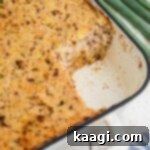 Cajun Cornbread Comfort 7 A corner of a dish with Cajun cornbread dressing made in it, with a corner scooped out.