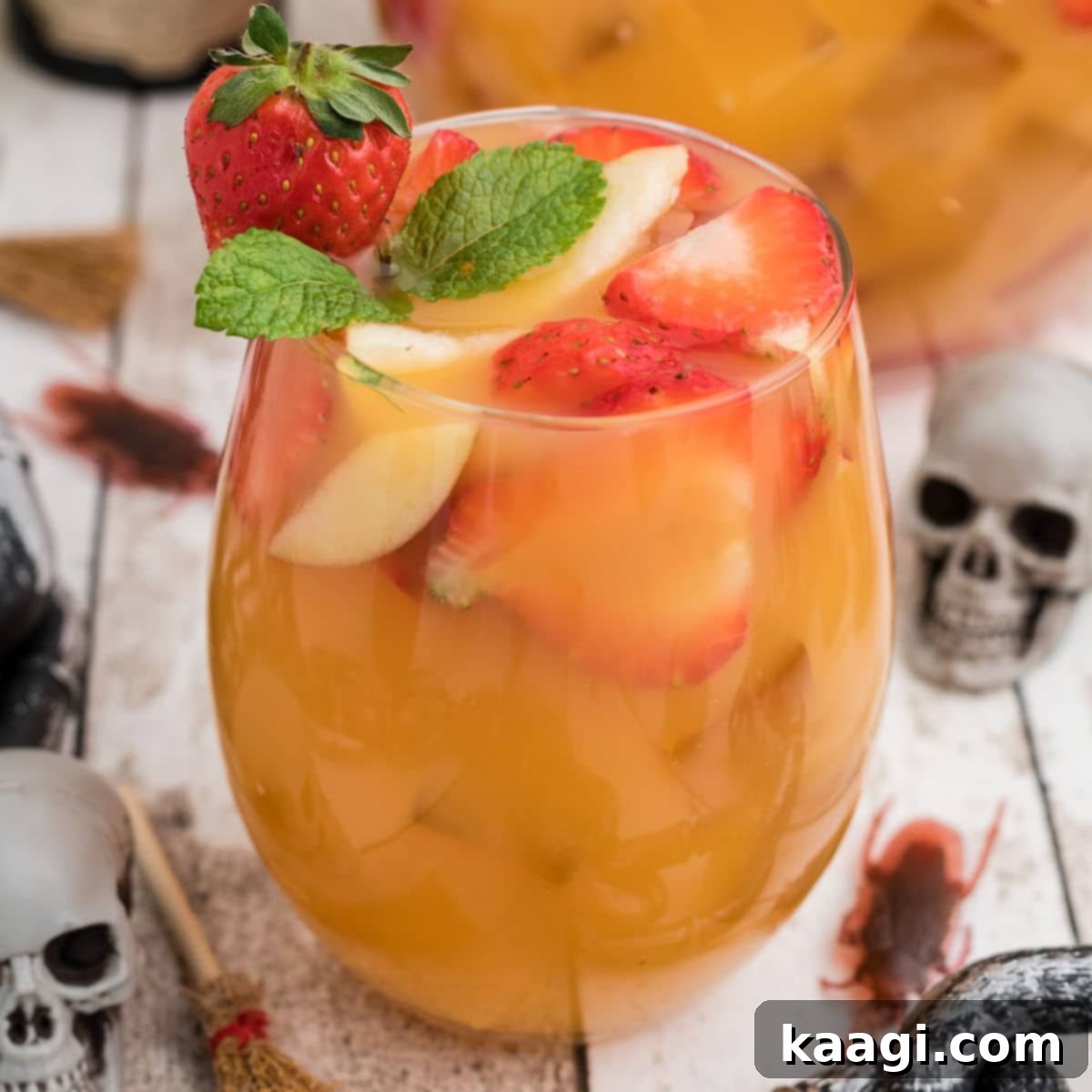 Close up of a glass of Halloween jungle juice with a skeleton in the background.