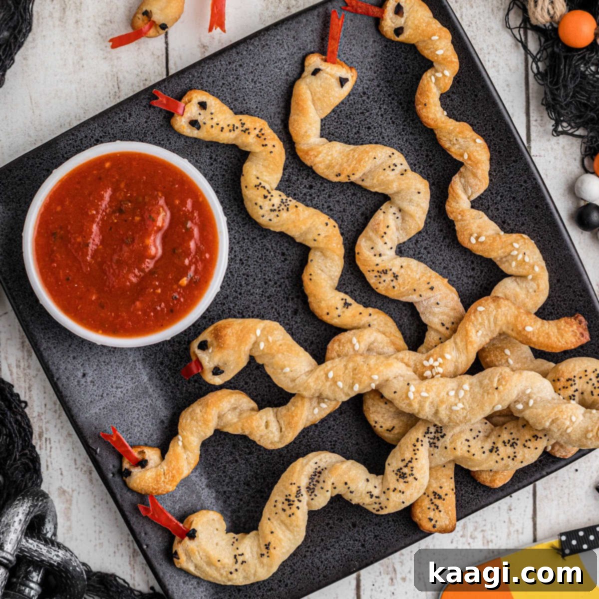 A plate full of breadstick rattlers with a marinara sauce to dip.