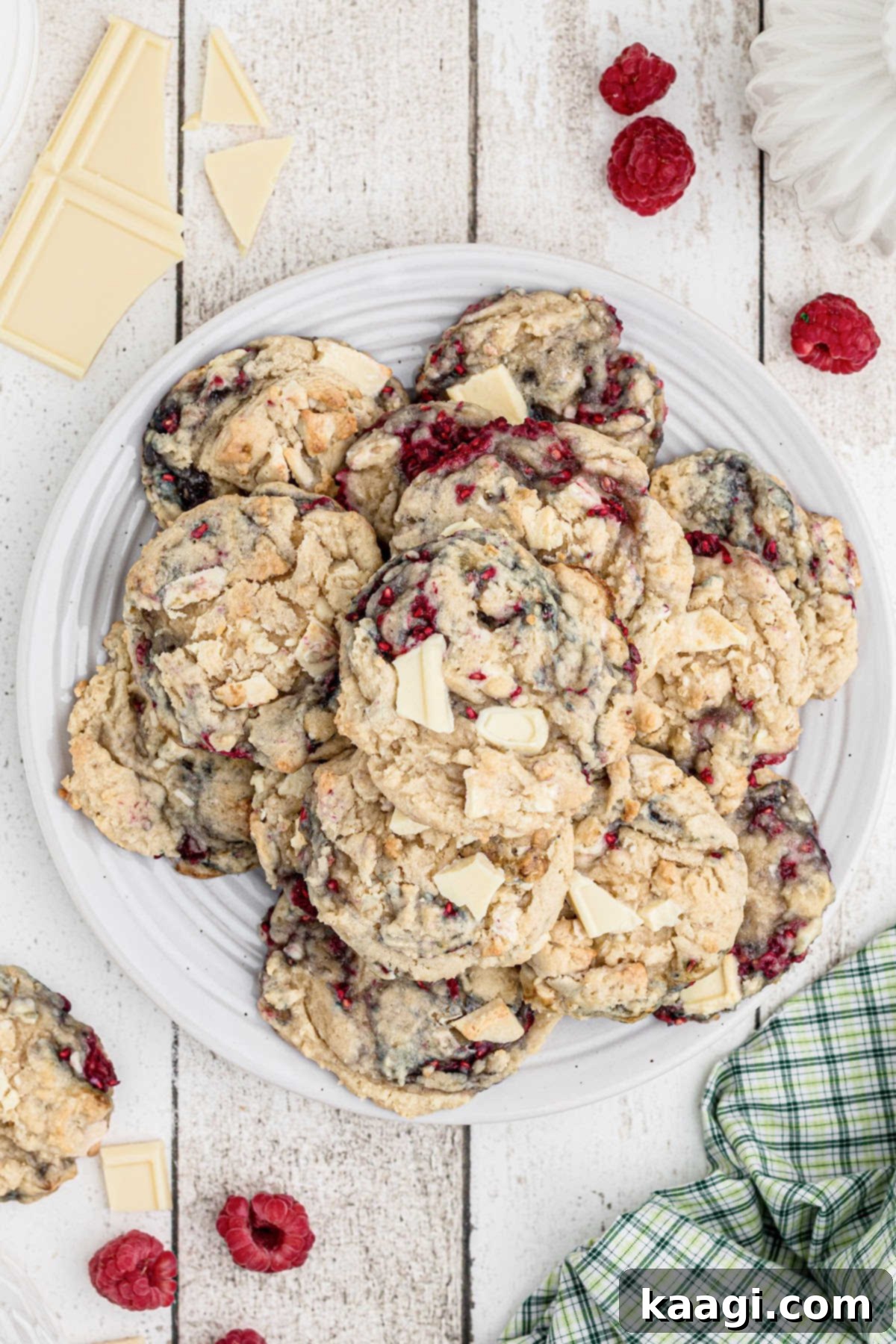 An inviting overhead shot of a plate full of freshly baked white chocolate raspberry cookies, ready to be enjoyed.