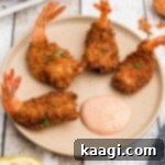 Close up of a plate of golden brown butterfly shrimp.