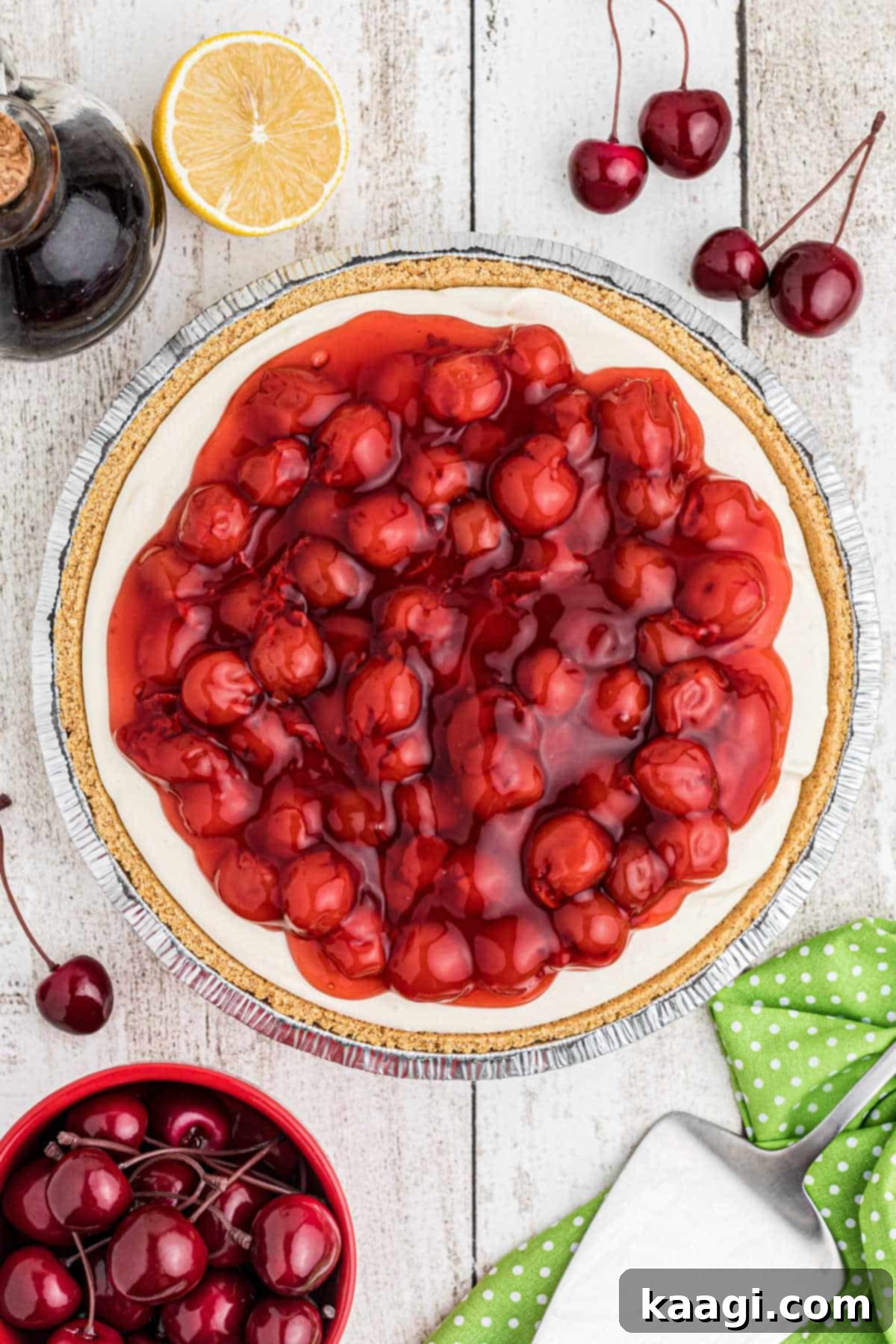 Full overhead shot of a vibrant no-bake cherry pie, surrounded by fresh red cherries, indicating its irresistible flavor and ease of preparation.