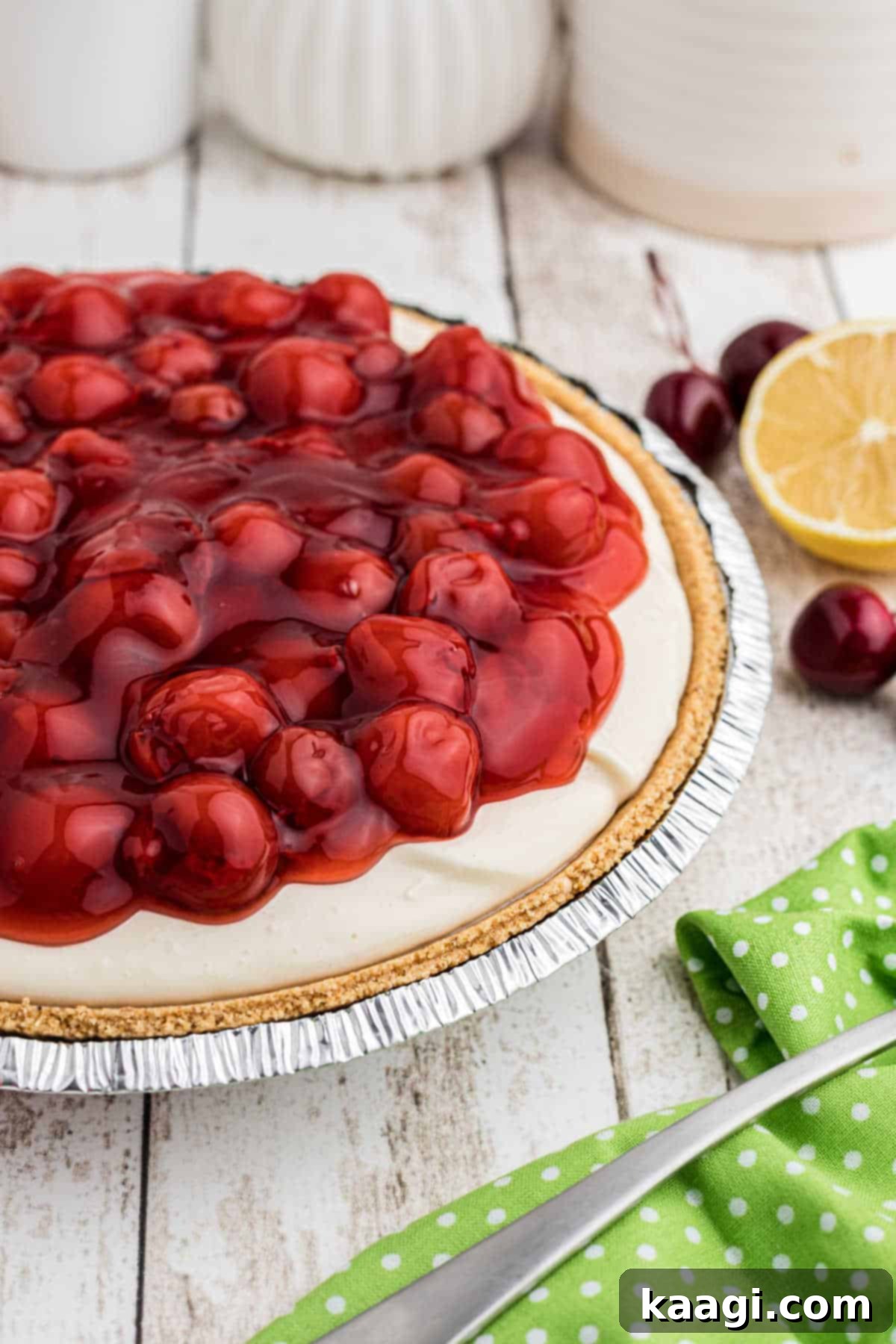 Side on view of a decadent no-bake cherry pie, showing the thick, creamy layer and glistening cherry topping, ready to be served.