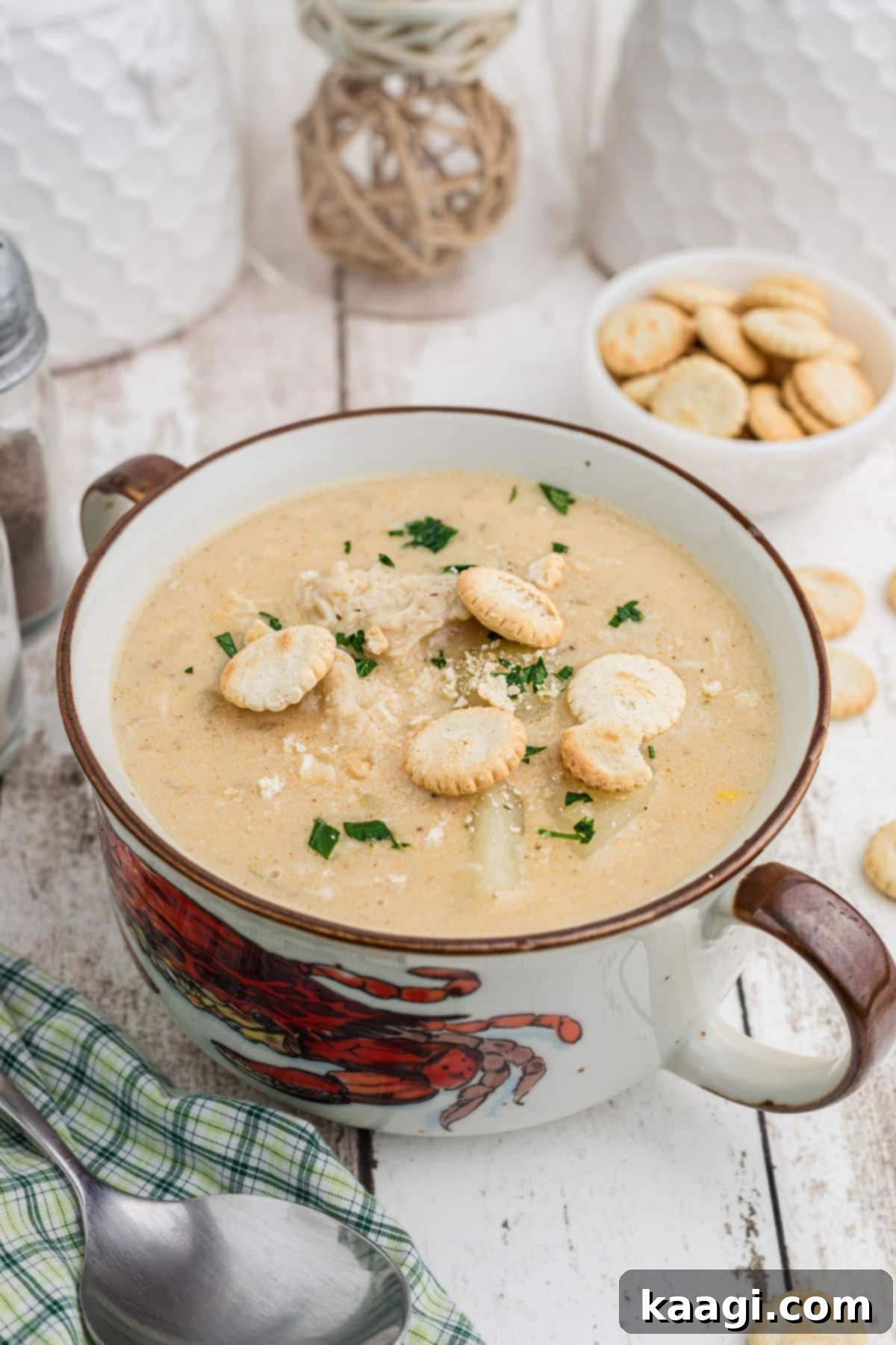 A charming portrait shot of a bowl of crab chowder, featuring a decorative crab bowl.