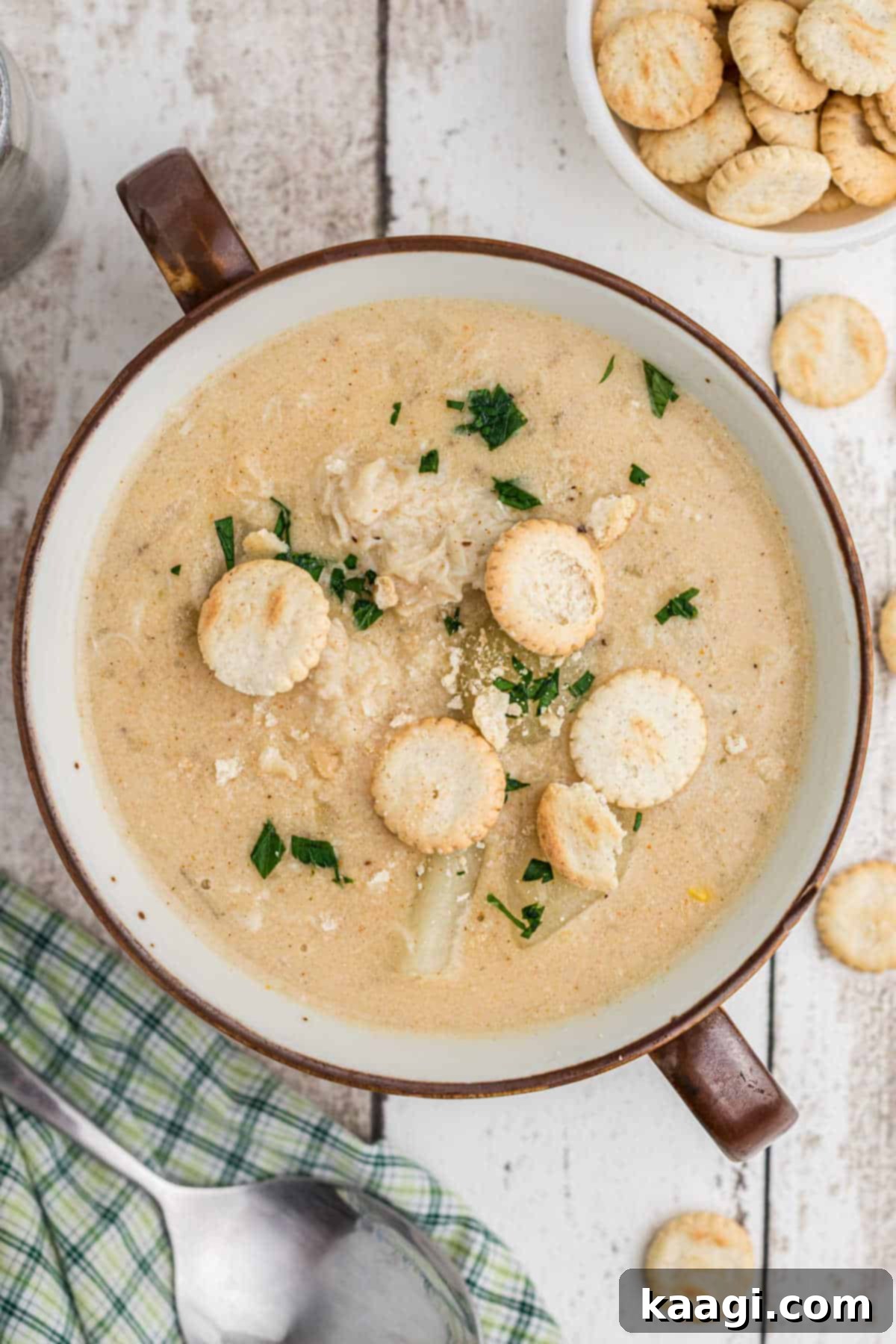 An overhead shot of a beautifully garnished bowl of crab chowder, invitingly presented.