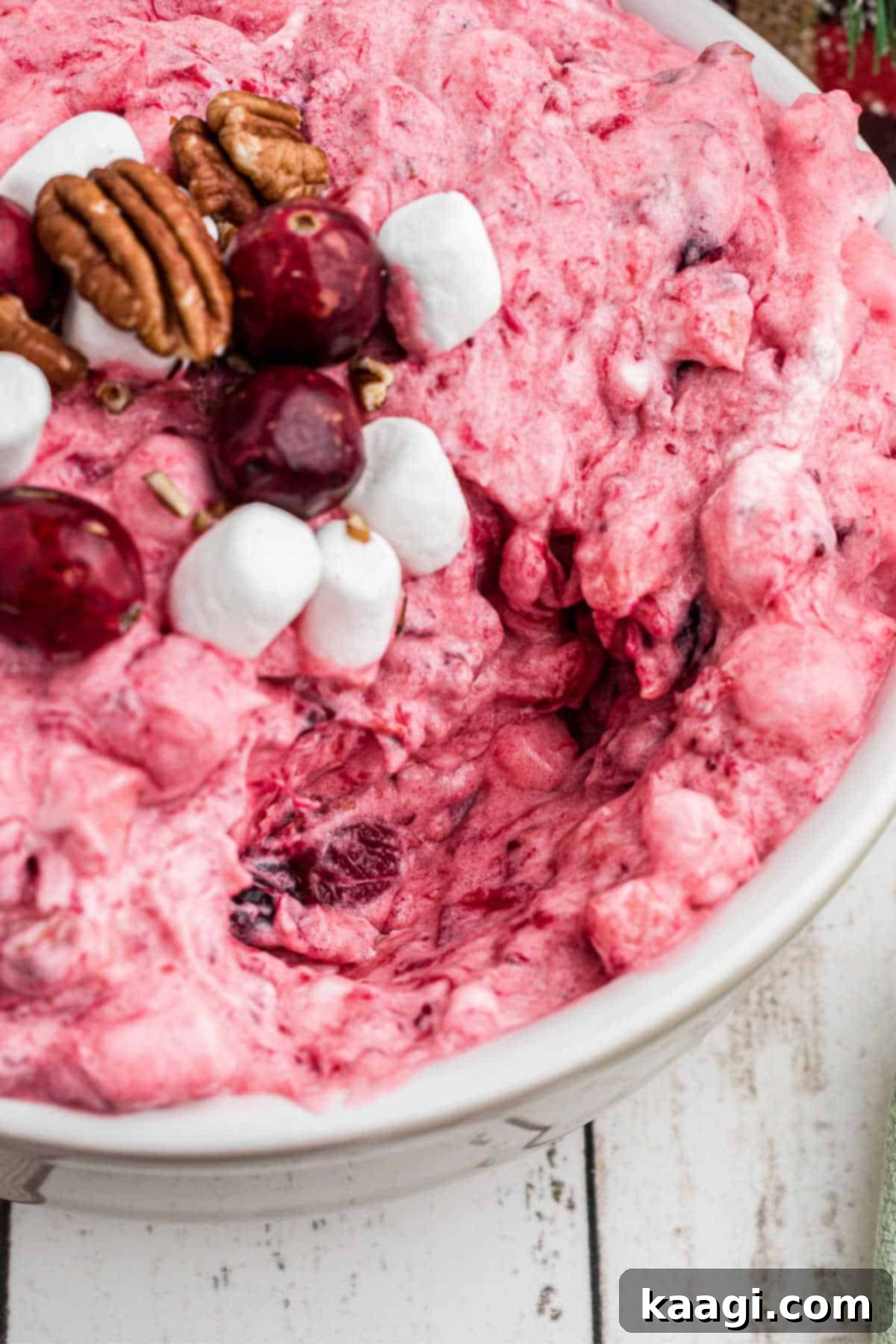 Cranberry salad with a scoop missing, showing the texture and ingredients within.