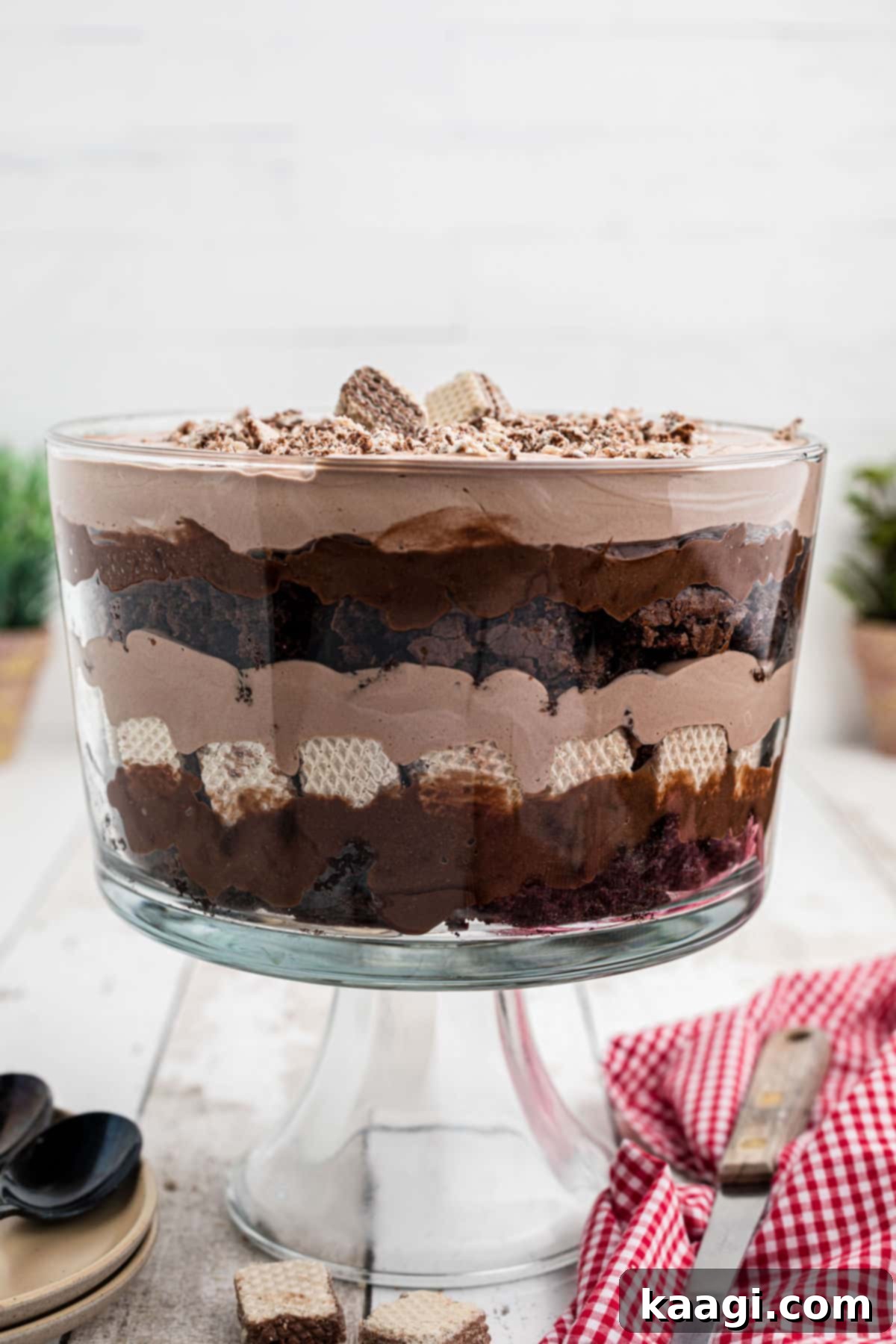 A trifle dish full of nutella trifle, showcasing layers of brownies, nutella chocolate, nutella flavored cream, hazelnut cookies and chocolate pudding from an overhead view.