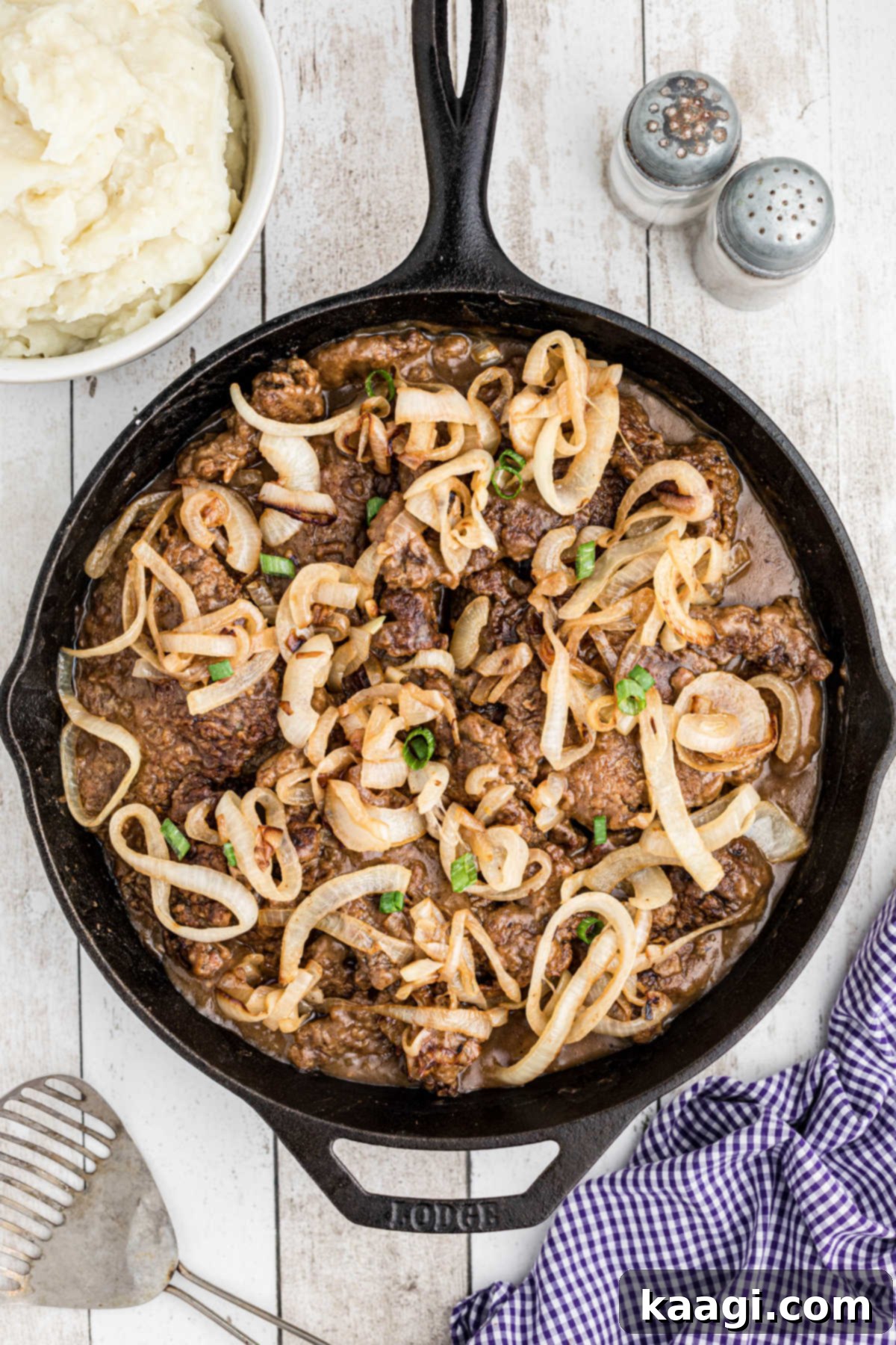Overhead shot of a cast iron pan with southern liver and onions with gravy.
