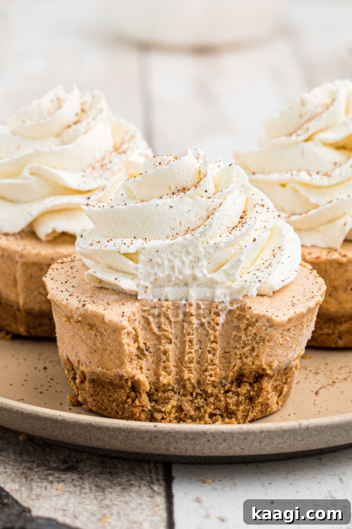 Close up of a no bake mini pumpkin pie with a bite taken from the front, showing the creamy filling and graham cracker crust.