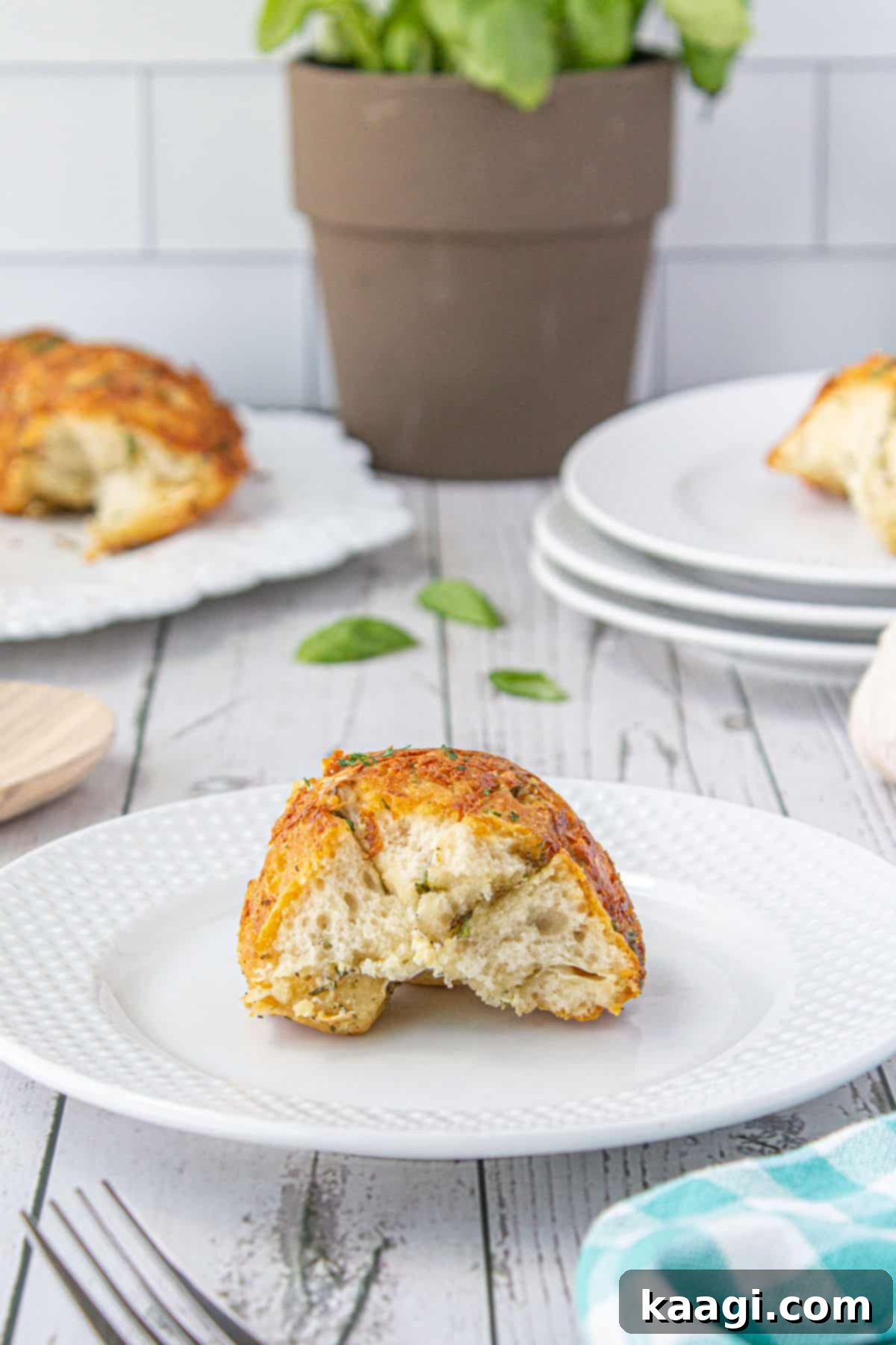 A close-up shot of a piece of monkey bread on a plate, showing its cheesy, pull-apart texture.