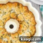 Overhead close up shot of Italian monkey bread in a bundt pan - cropped square, golden and cheesy.