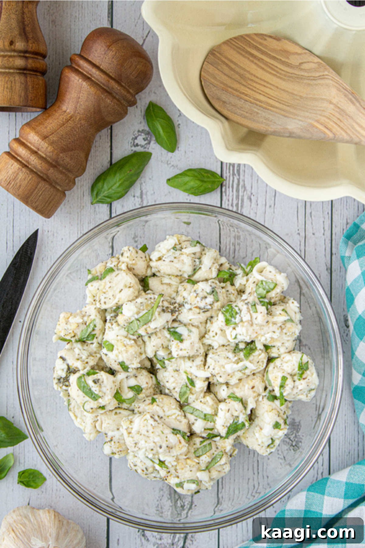 A large mixing bowl with mixed up biscuit dough, cheese, and seasonings, evenly coated.