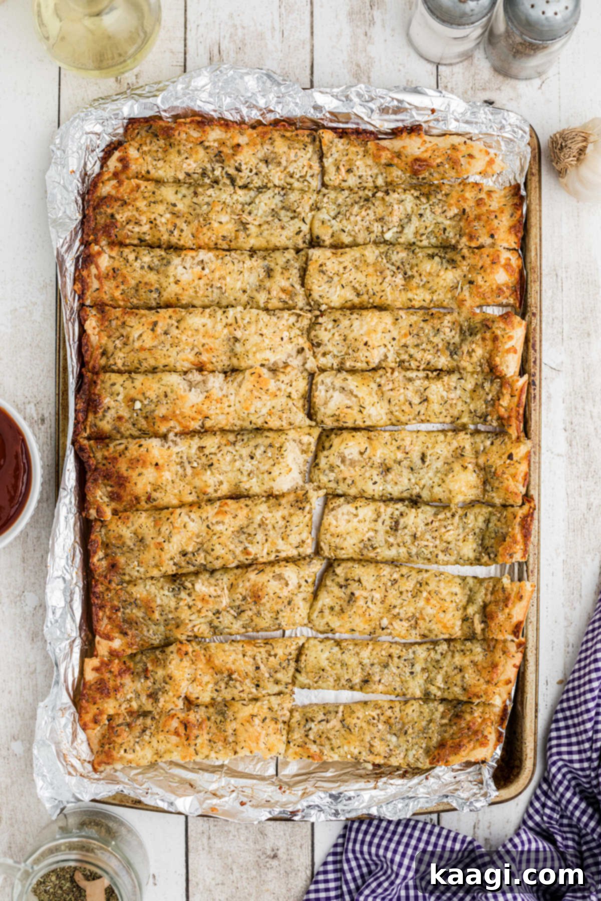 Mastering Little Caesars Cheesy Bread at Home 2 Full overhead shot of a pan full of homemade Little Caesars Italian cheese bread sticks, glistening with garlic butter and topped with melted cheese.