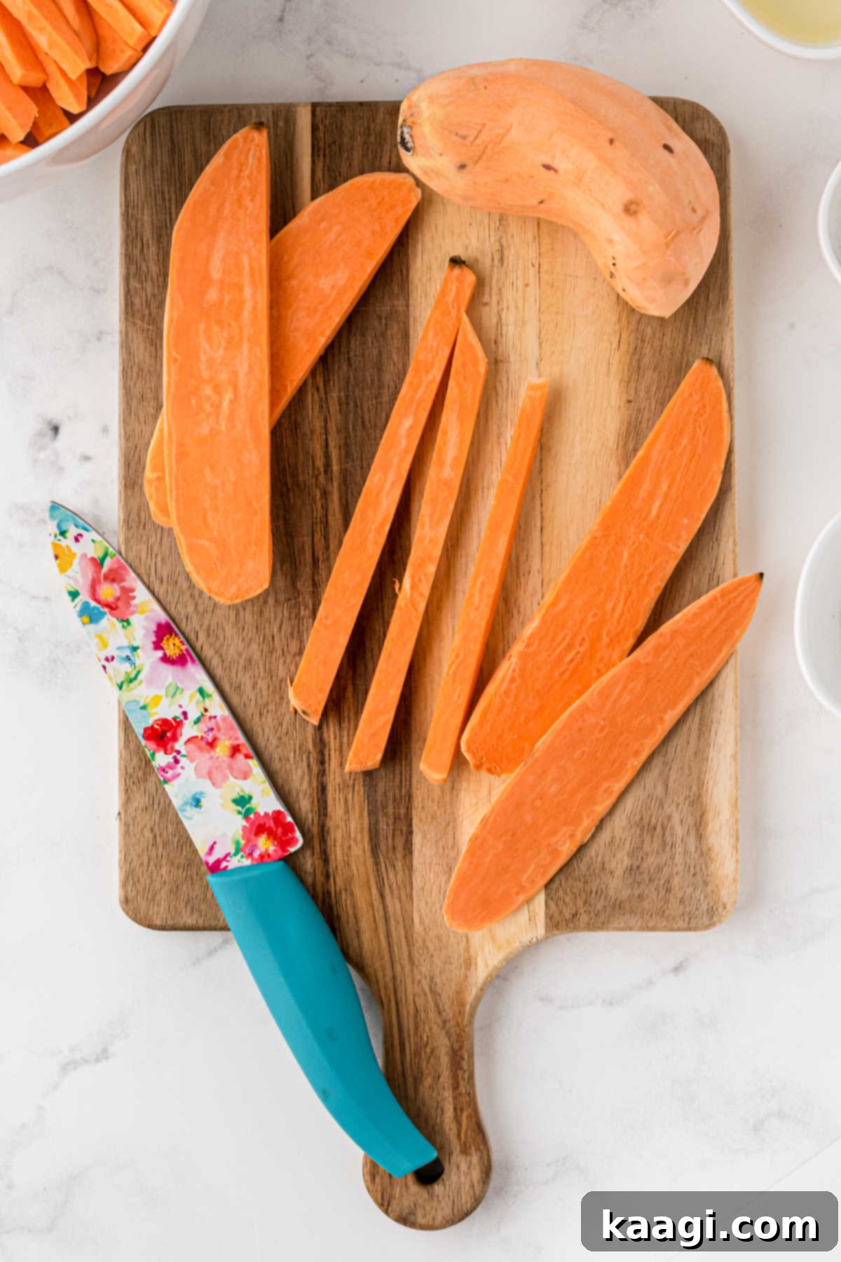 Sweet Potatoes cut into sticks with a knife.