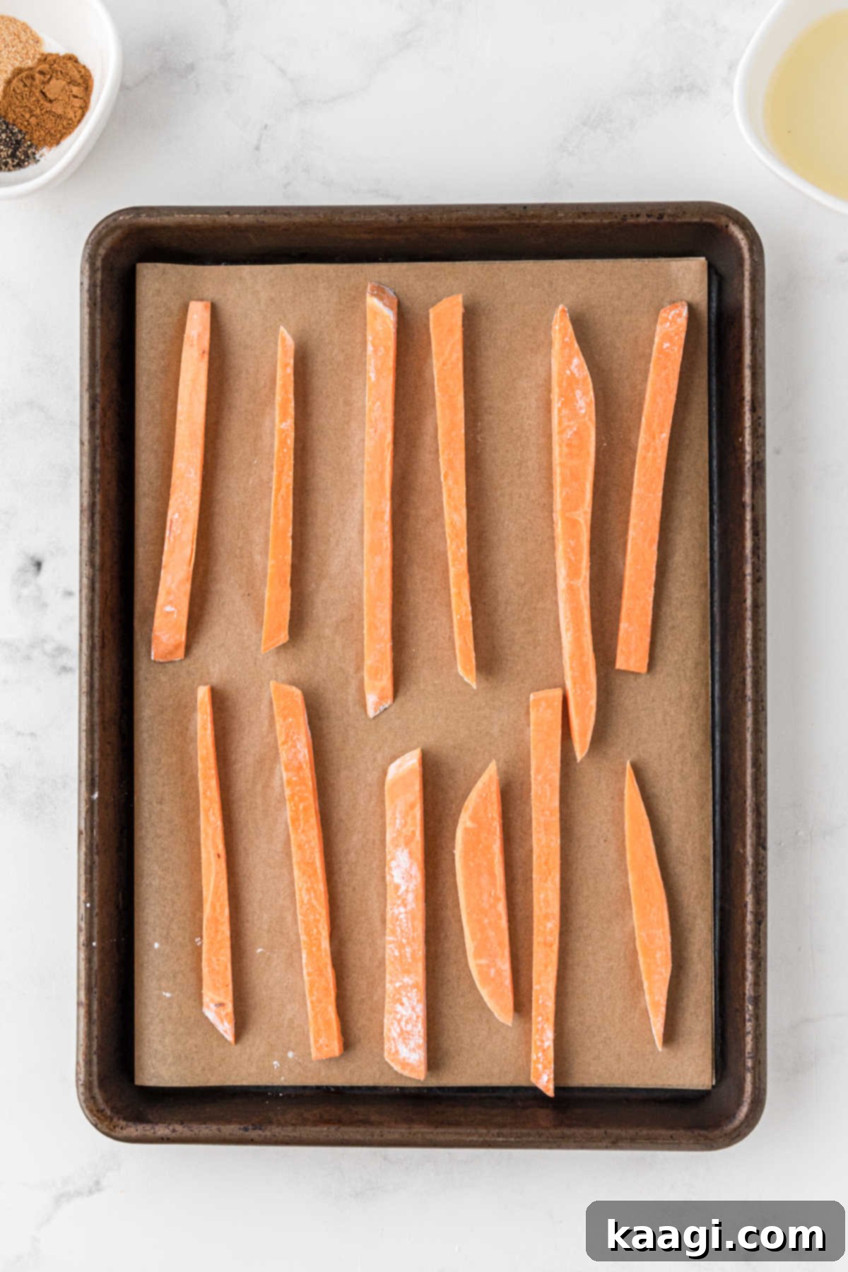 Sweet Potato fries on a baking sheet lined with parchment paper.