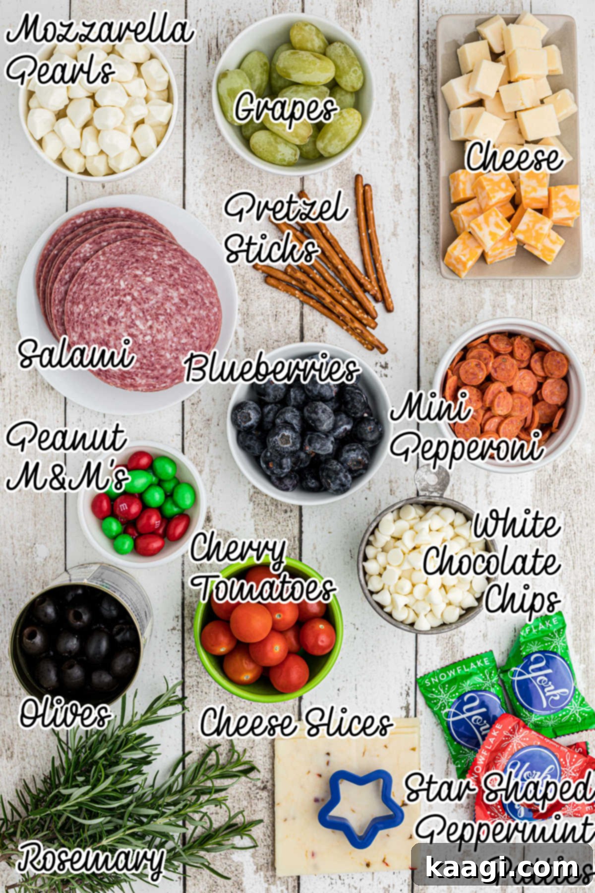 A vibrant selection of ingredients laid out, including various cheeses, cured meats, fruits, and decorative elements, ready for building a Christmas charcuterie board.