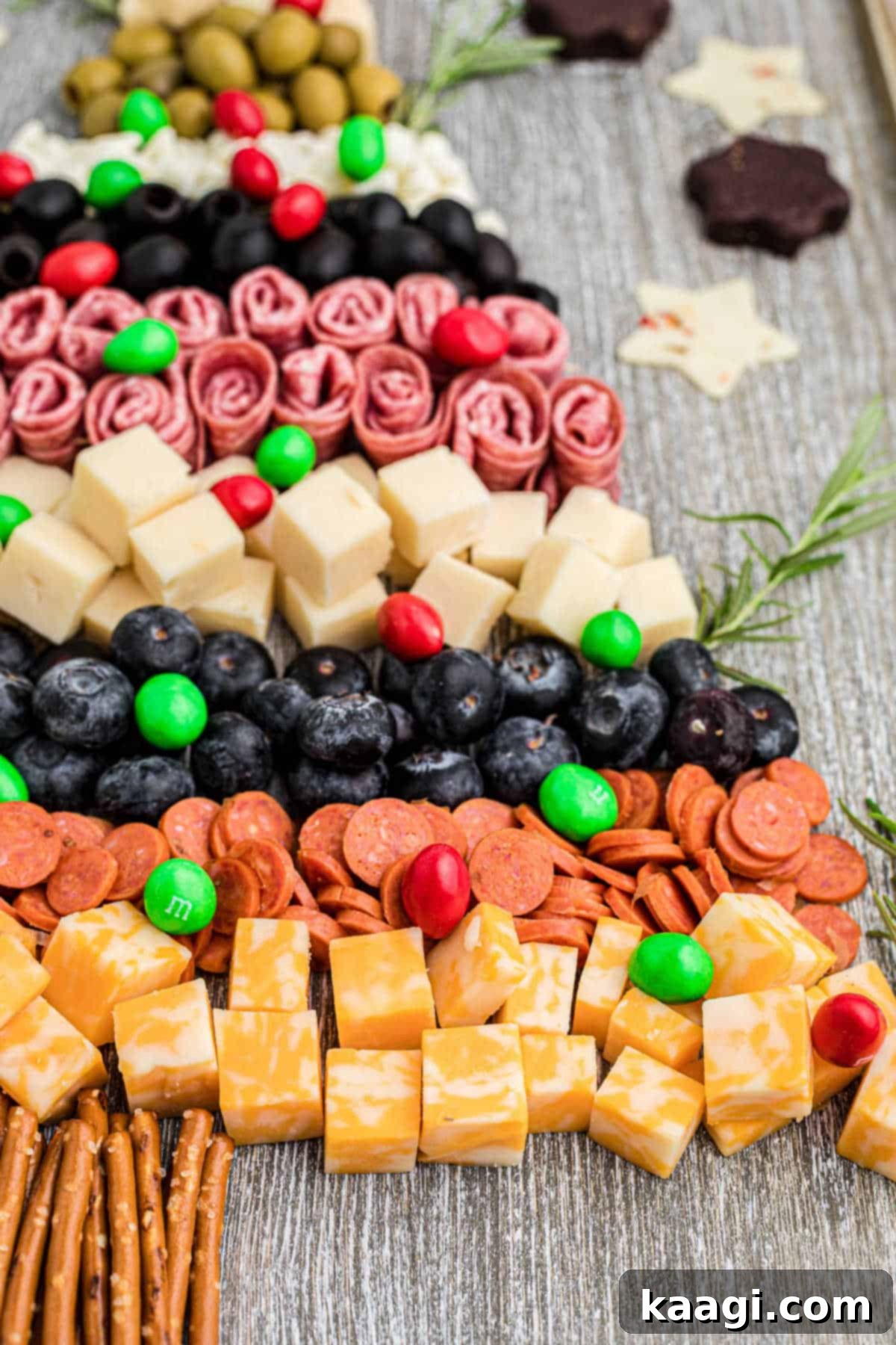 Close-up side view of a meticulously arranged Christmas charcuterie board, highlighting the diverse textures and colors of the ingredients.