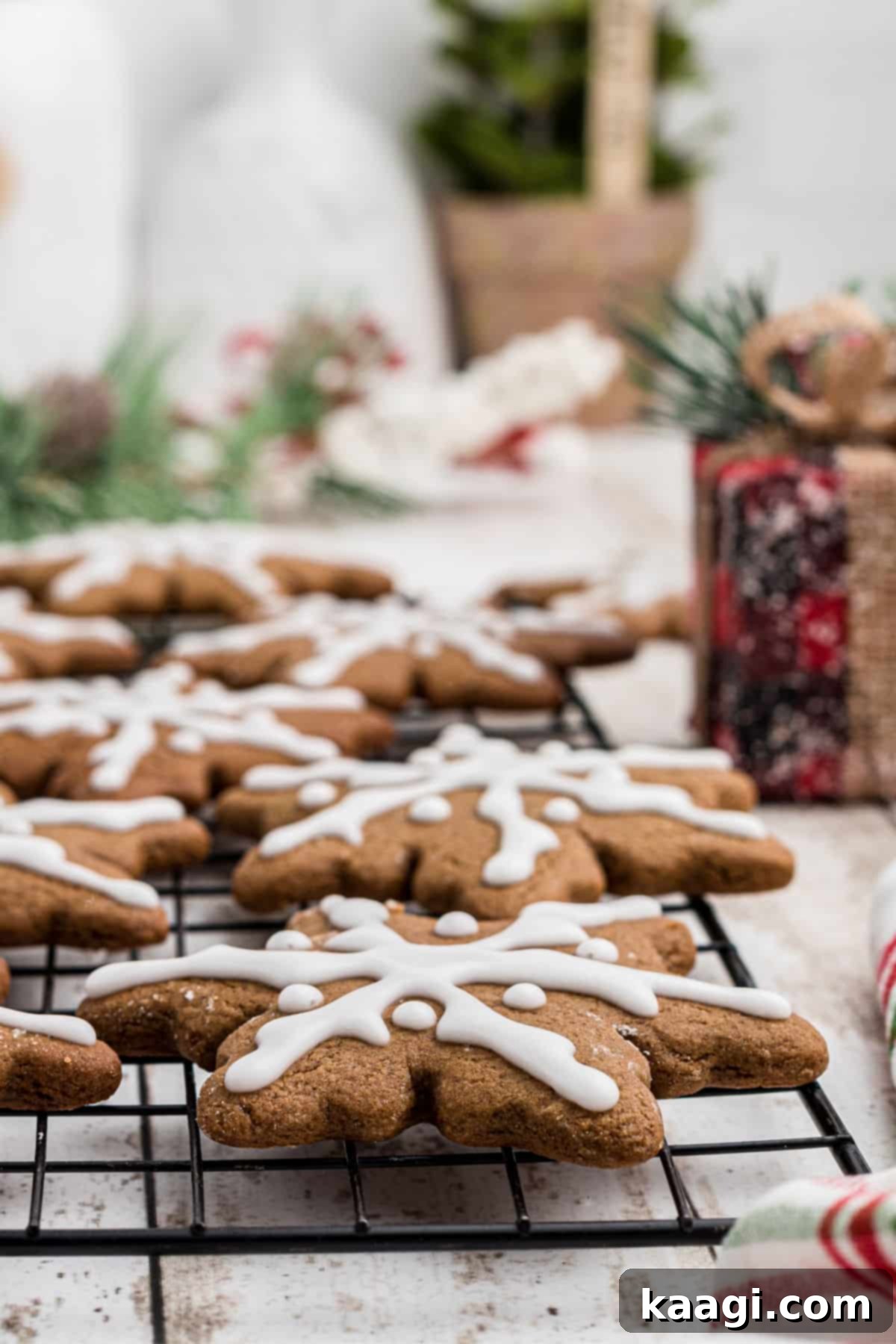Close up side shot of a wire rack with snowflake gingerbread cookies on them.