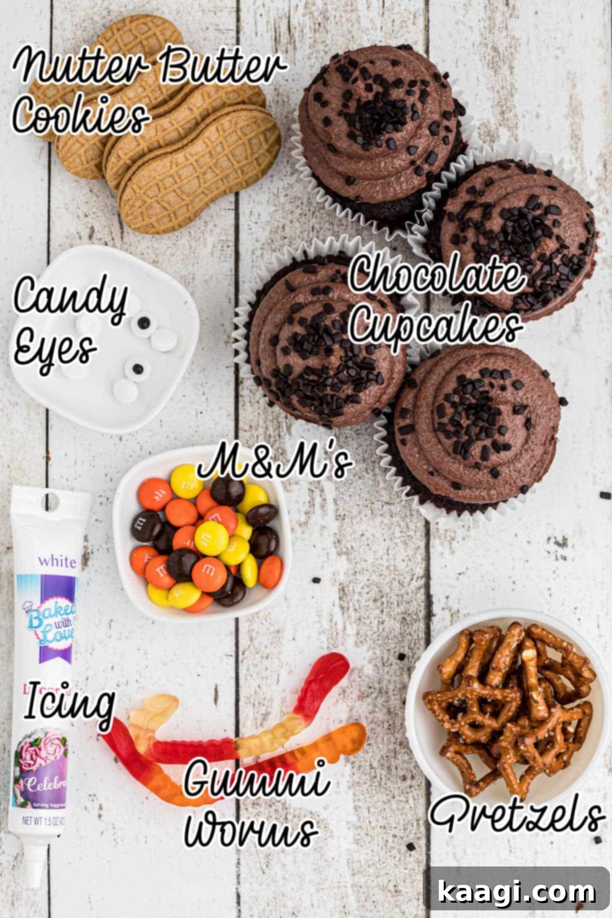 Thanksgiving Peanut Butter Turkeys 3 A flat lay photograph displaying all the ingredients required to assemble Nutter Butter Turkey Cupcakes, including cookies, M&M's, pretzels, and cupcakes.