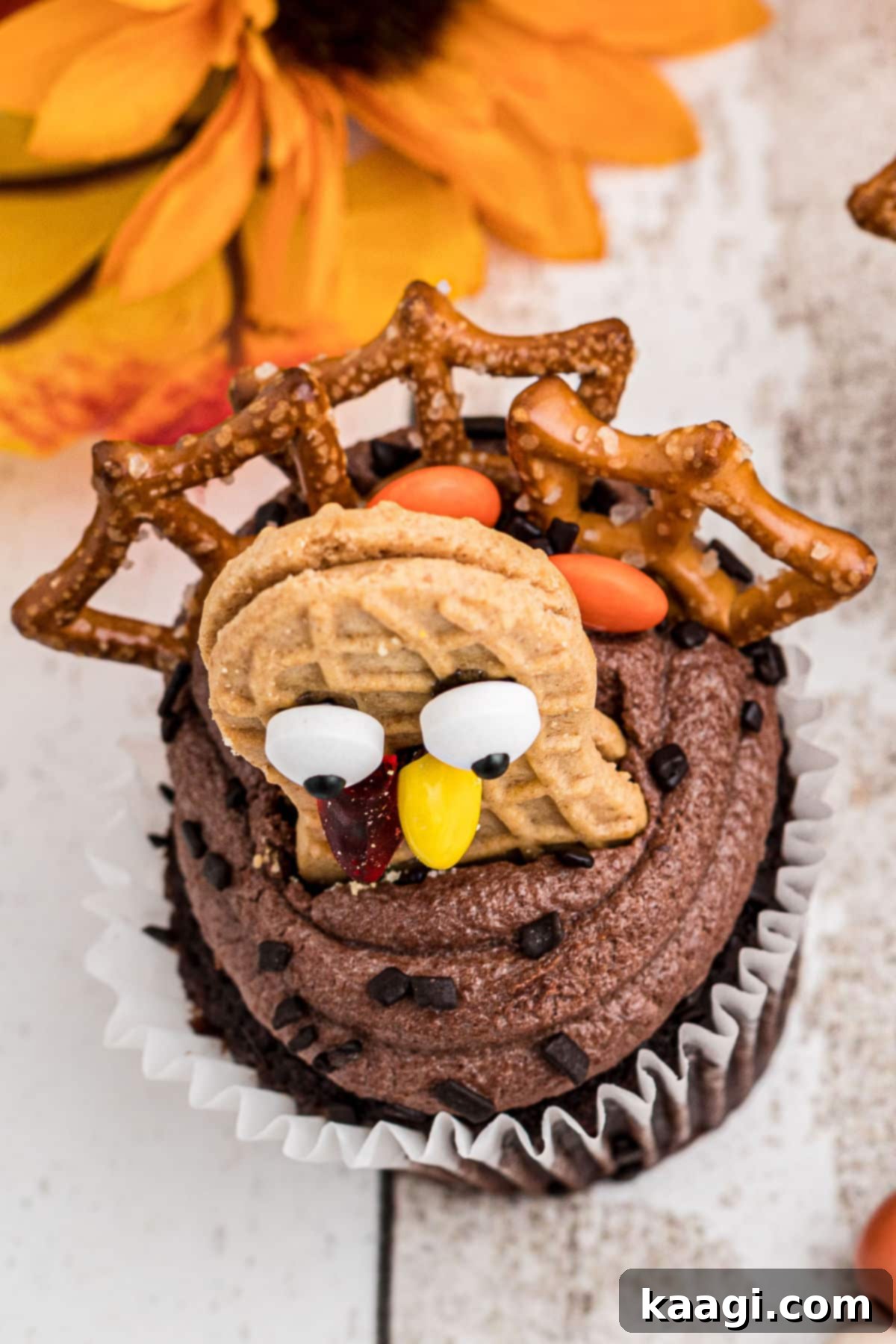 Thanksgiving Peanut Butter Turkeys 4 An overhead view of a single Nutter Butter Turkey Cupcake, highlighting the pretzel tail feathers and candy decorations against the chocolate frosting.