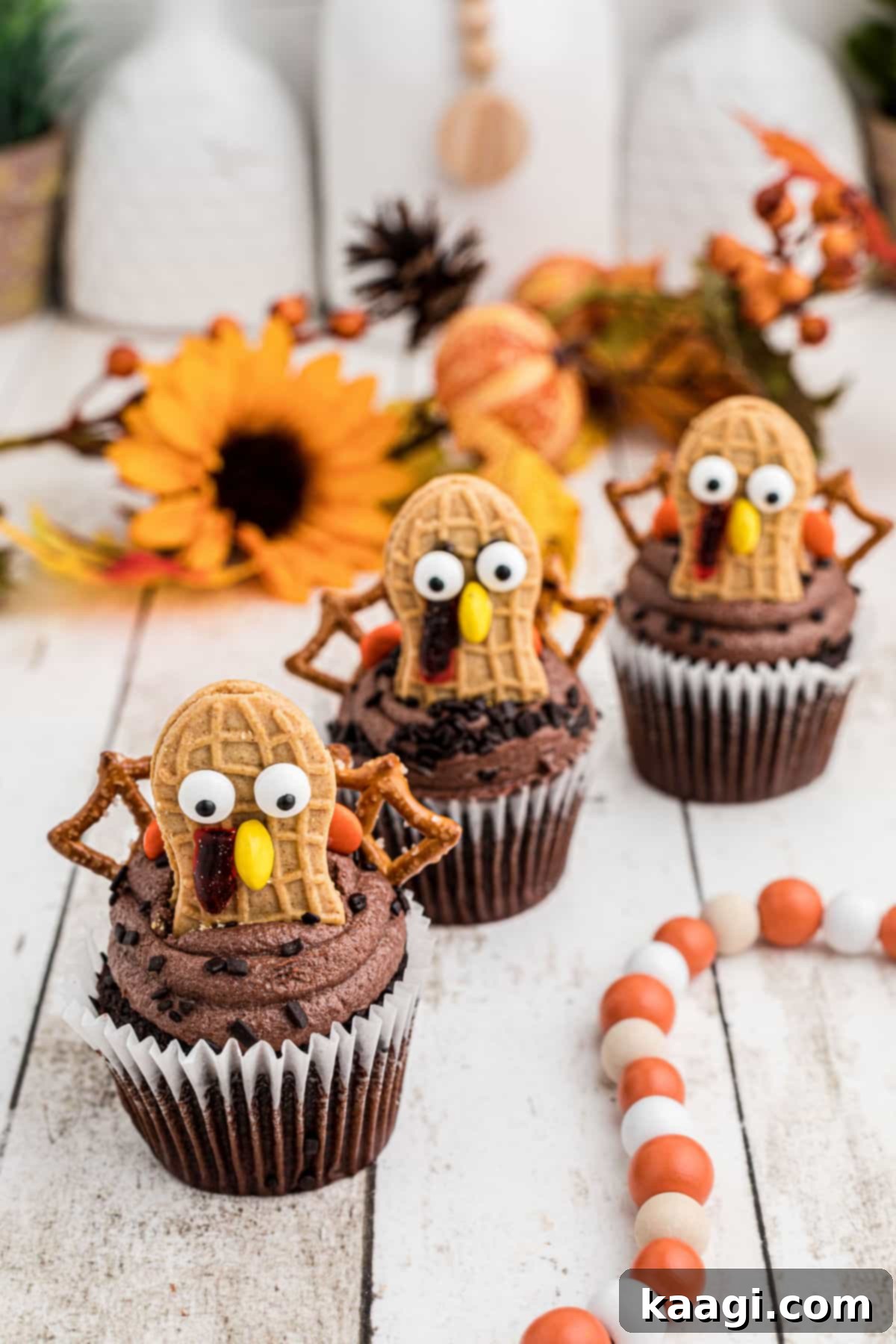 Thanksgiving Peanut Butter Turkeys 5 Three Nutter Butter Turkey Cupcakes lined up, showing their adorable faces, colorful pretzel tails, and candy details.