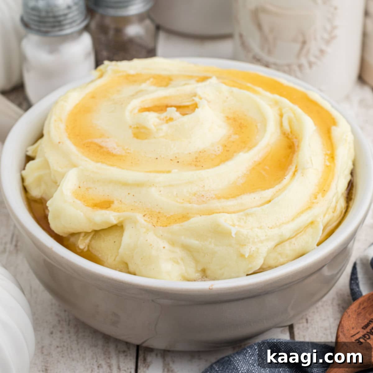 A side shot of a bowl of fluffy Amish mashed potatoes, ready to be enjoyed.
