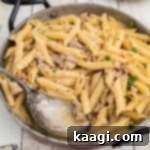 A close up picture of a one pot turkey pasta in a skillet with a spoon.
