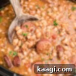 Easy Slow Cooker Hoppin John 7 Close up shot of a crock pot hoppin john with a spoon, showing its hearty texture.