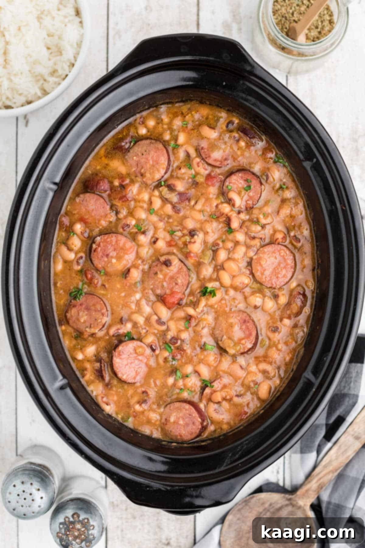 Easy Slow Cooker Hoppin John 4 A close-up view of Crock Pot Hoppin' John, rich with black-eyed peas, smoked sausage, and aromatic vegetables, simmering to perfection.