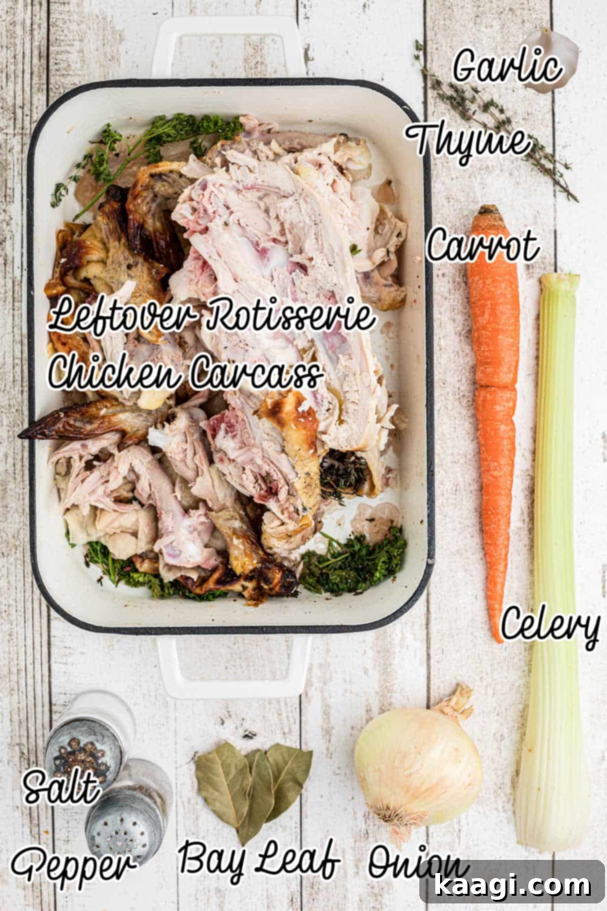 An overhead shot of various fresh ingredients including carrots, celery, onions, garlic, and bay leaves, laid out for making rotisserie chicken bone broth.