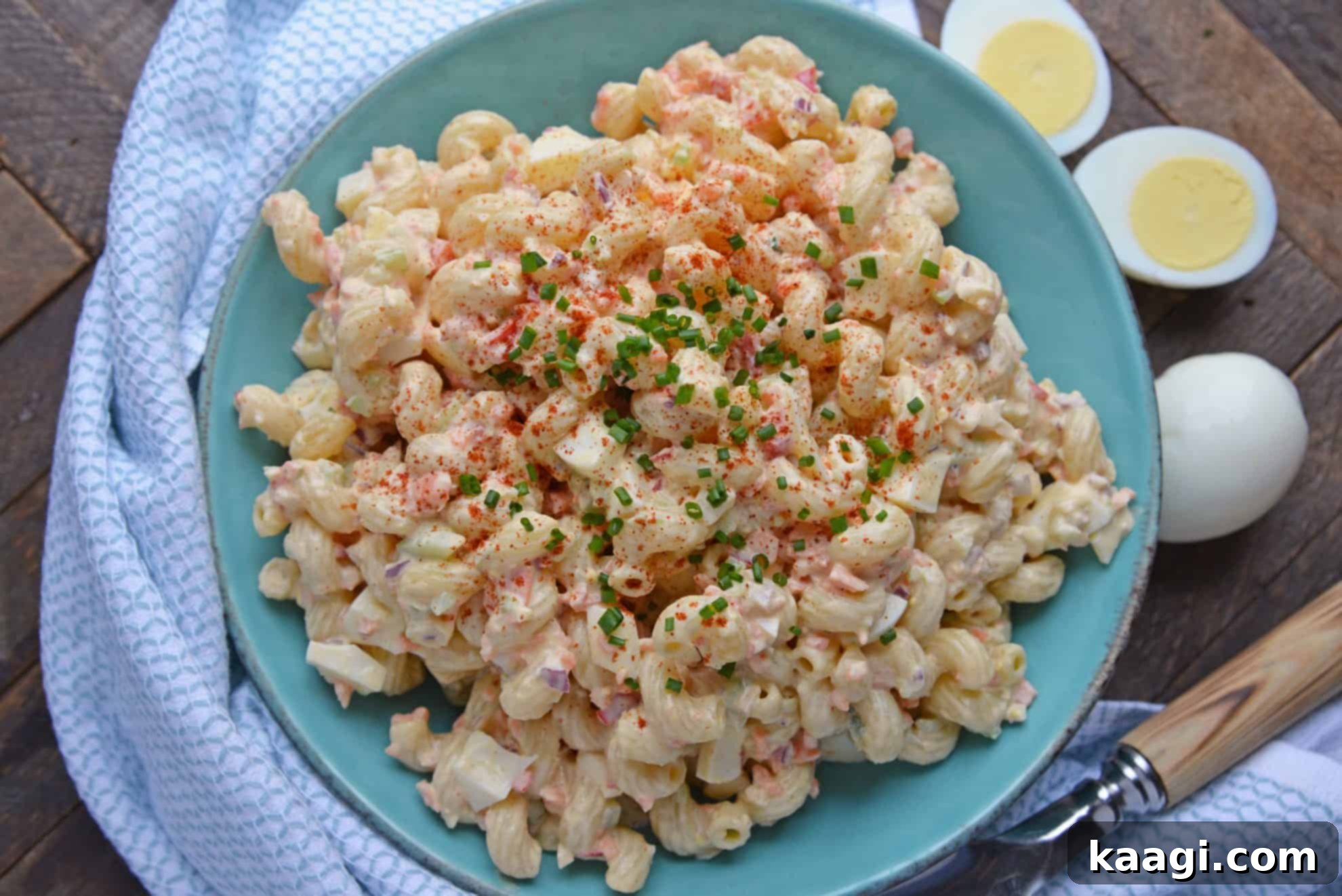 Second Life for Deviled Eggs 5 A vibrant bowl of deviled egg macaroni salad, garnished with fresh green onions and a sprinkle of paprika.