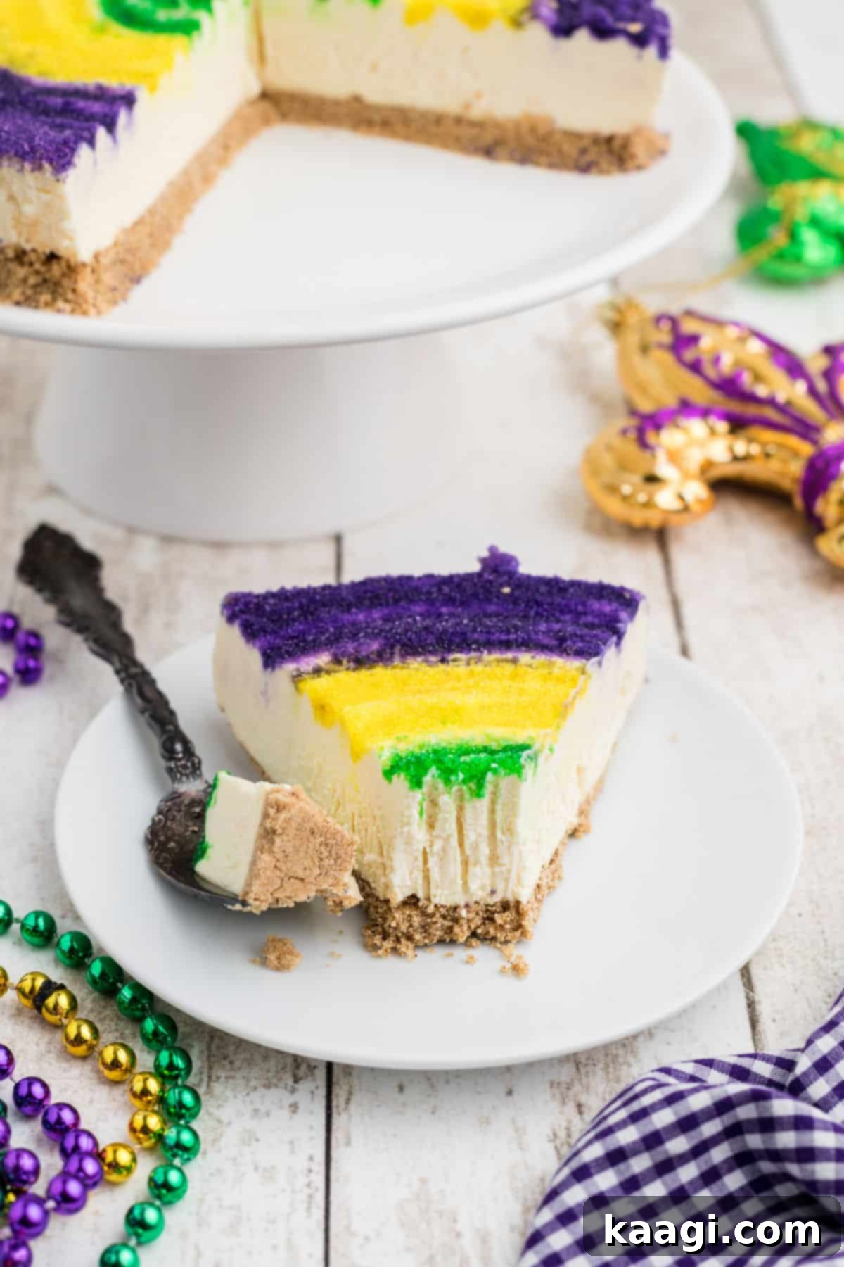Festive Mardi Gras Cheesecake 6 Front view of a slice of king cake cheesecake with a fork having taken a piece of the front.