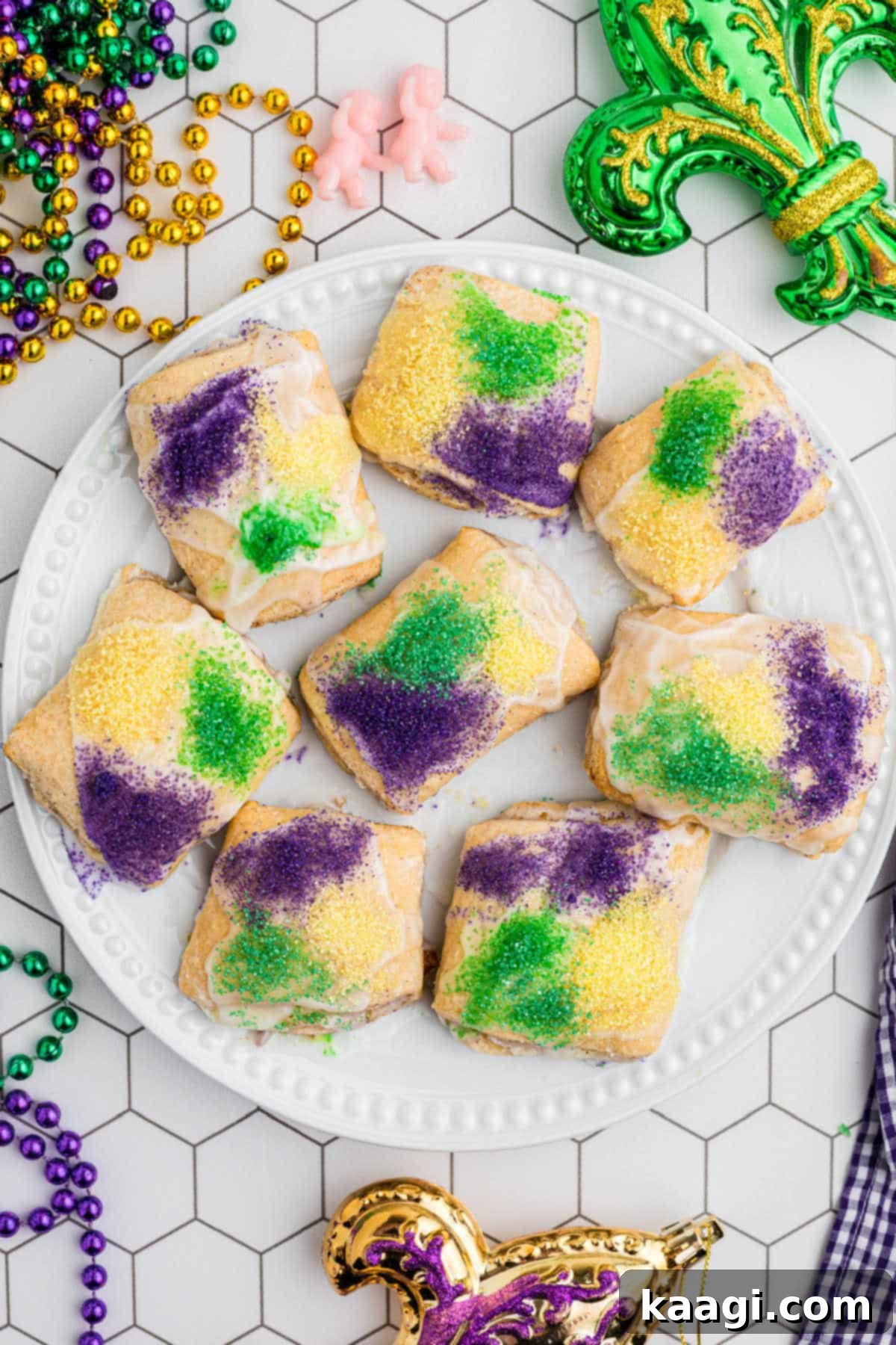 An inviting overhead view of a perfectly arranged plate of golden-brown King Cake Bites, drizzled with glaze and colorful sanding sugars, ready to be enjoyed.