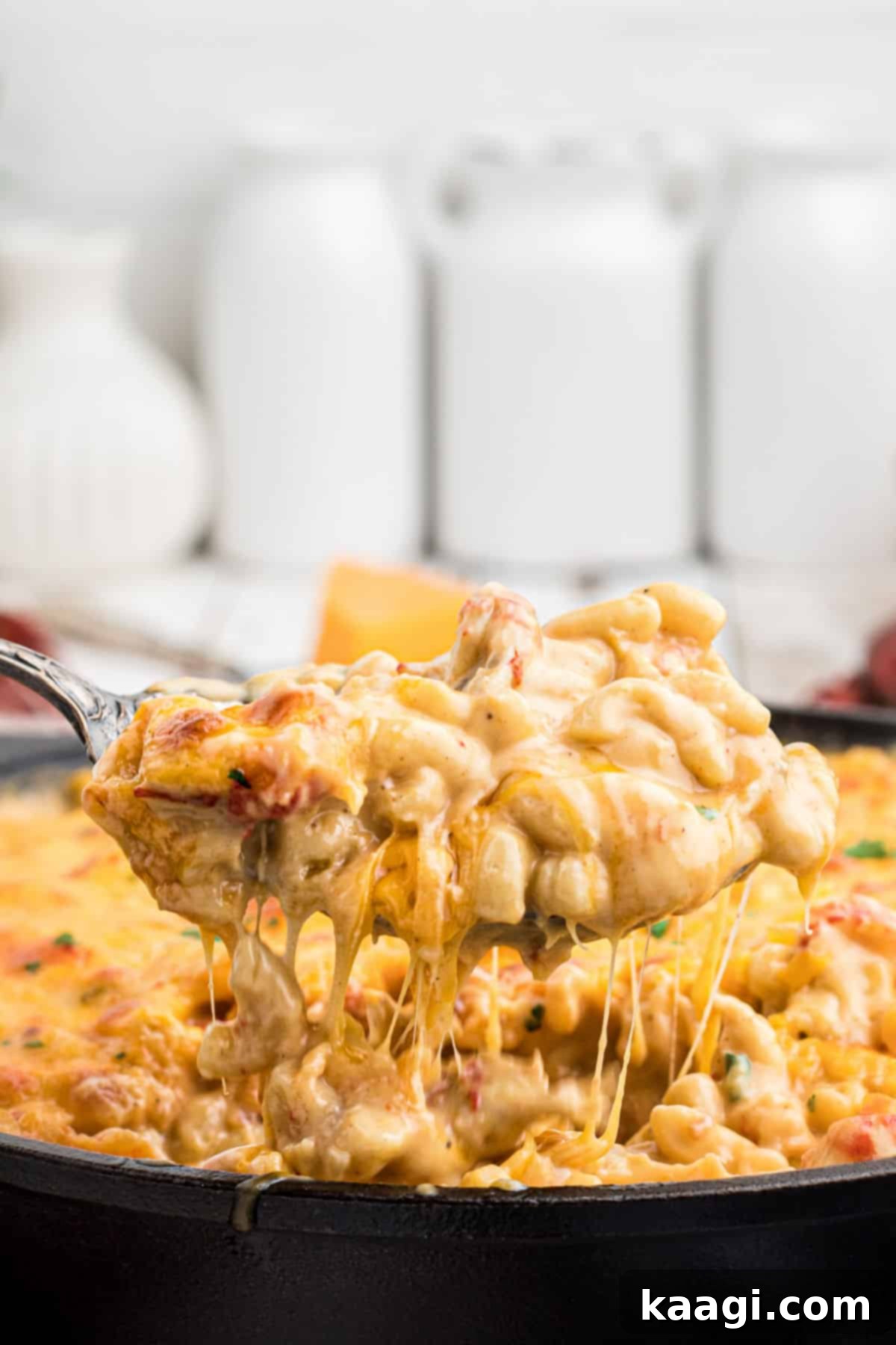 Close up side shot of a spoon lifting out some cheesy crawfish mac and cheese.