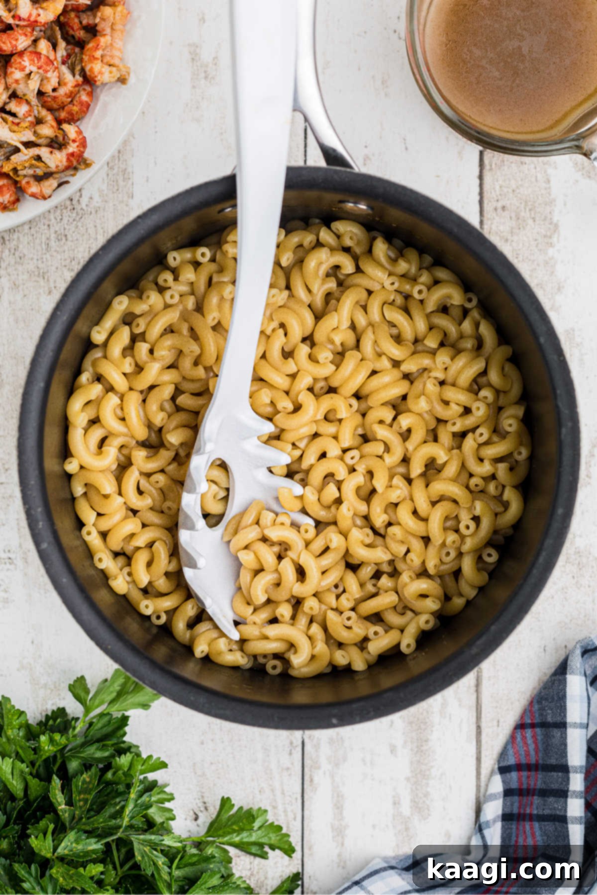 A large pot with elbow noodles being cooked.
