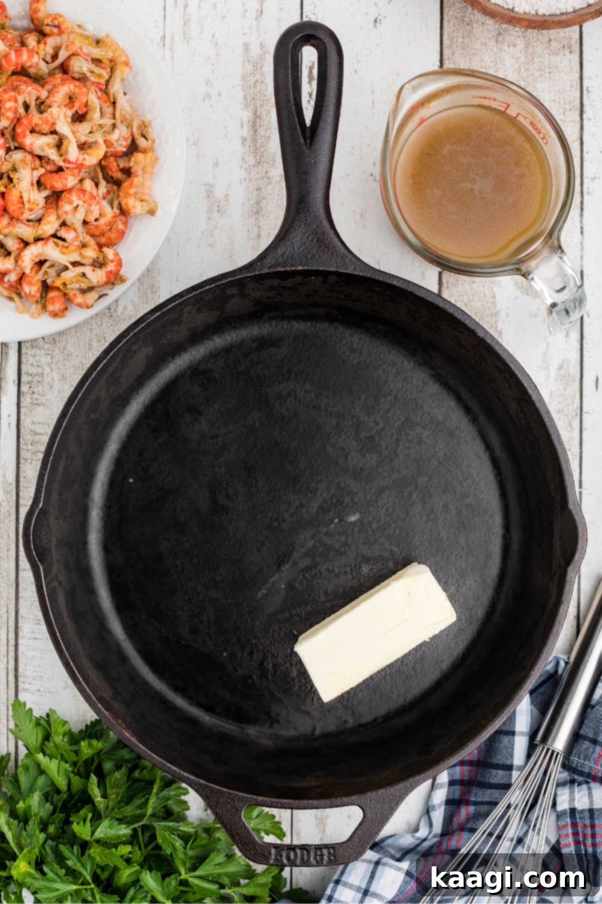 A black cast iron skillet with a block of butter;