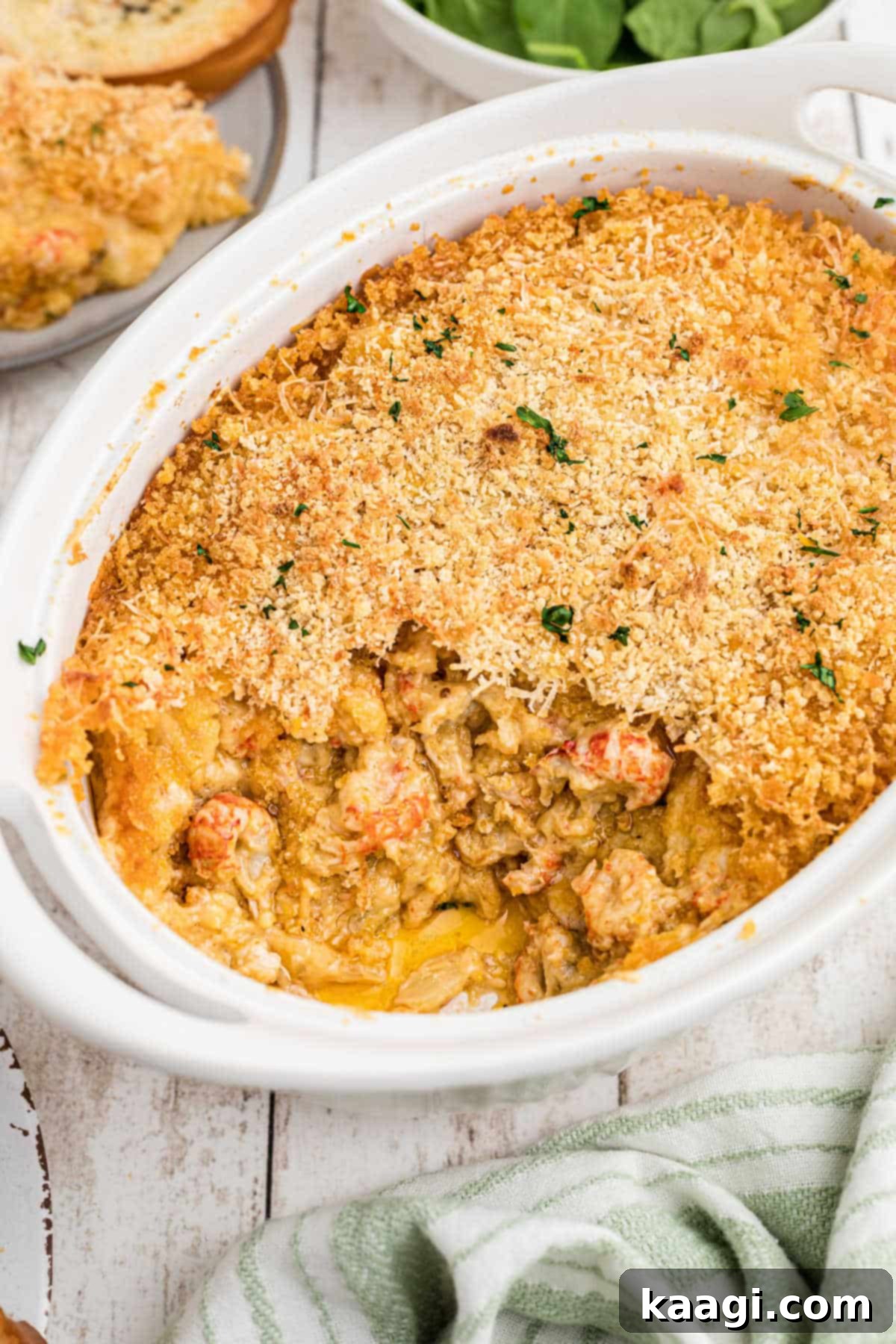 Portrait shot of a dish full of crawfish au gratin, garnished with fresh parsley.