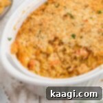 A dish with crawfish au gratin, a large part taken, showing the rich interior.